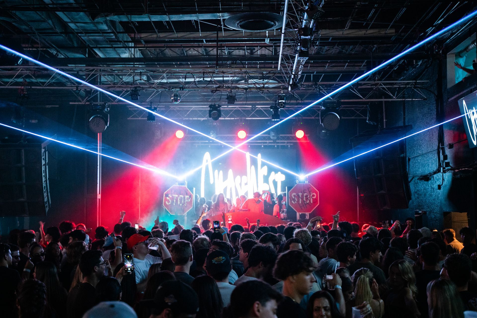 A crowd of people are standing in front of a stage at a concert.