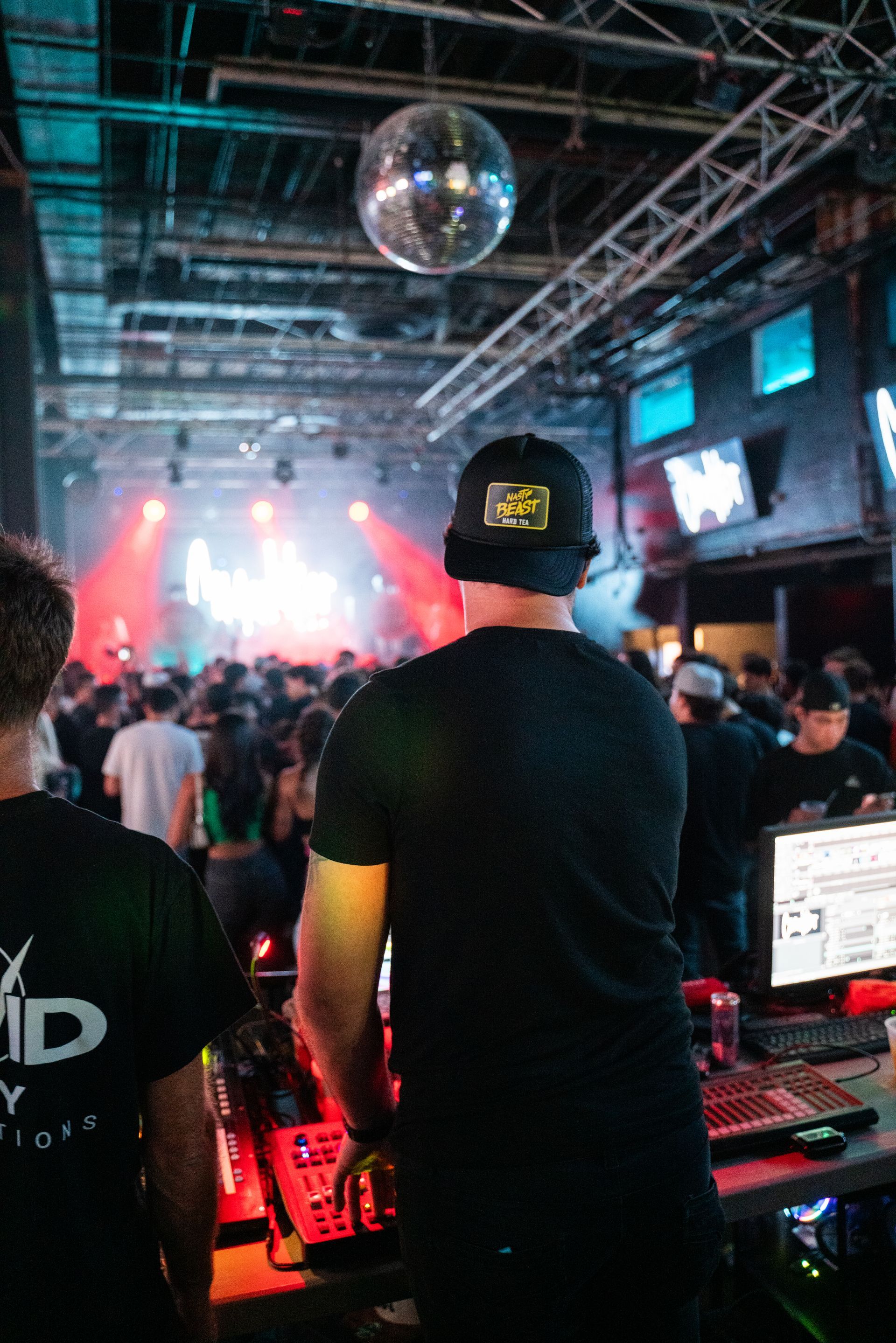 A man in a black shirt is standing in front of a crowd at a concert.