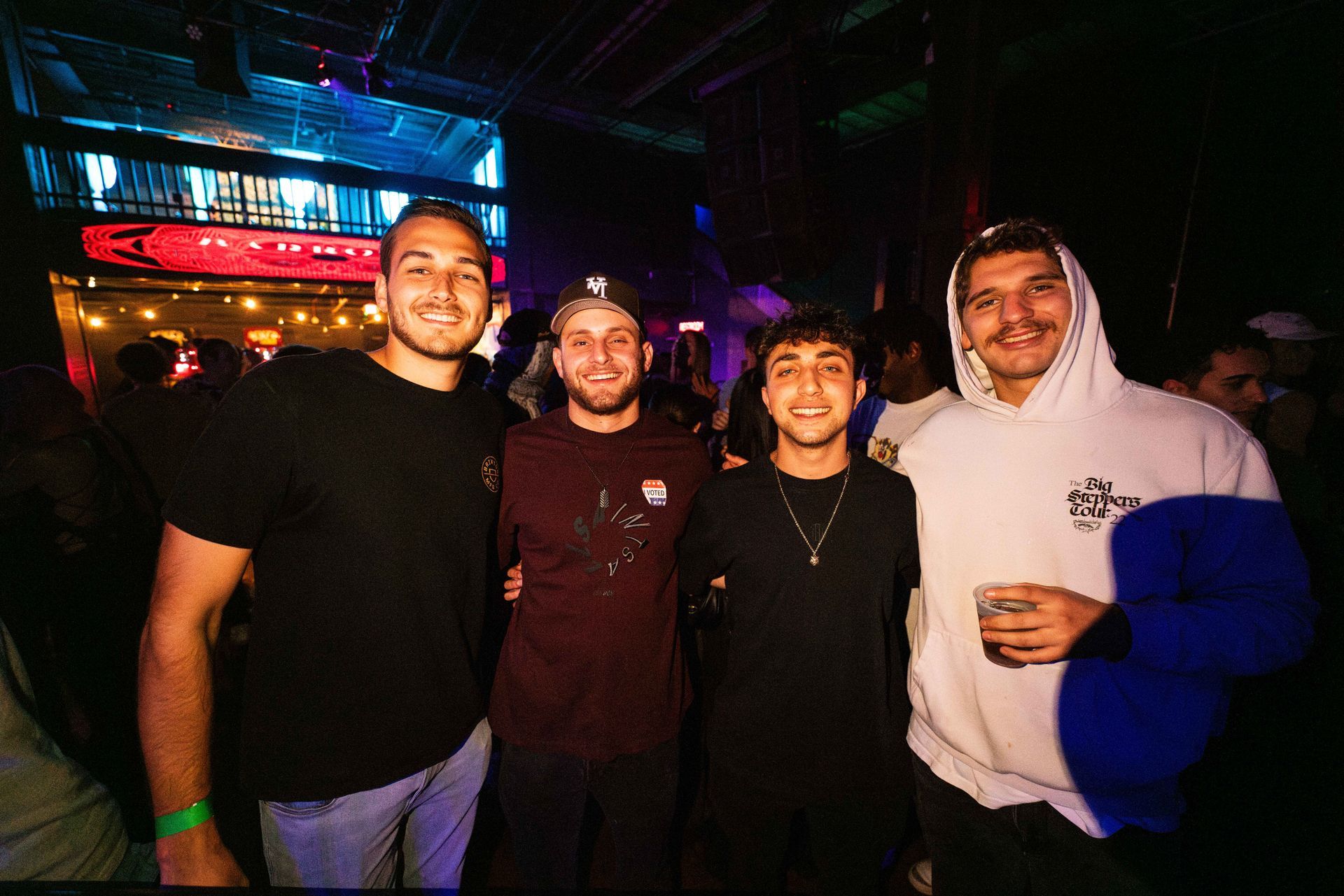 A group of young men are posing for a picture in a dark room.