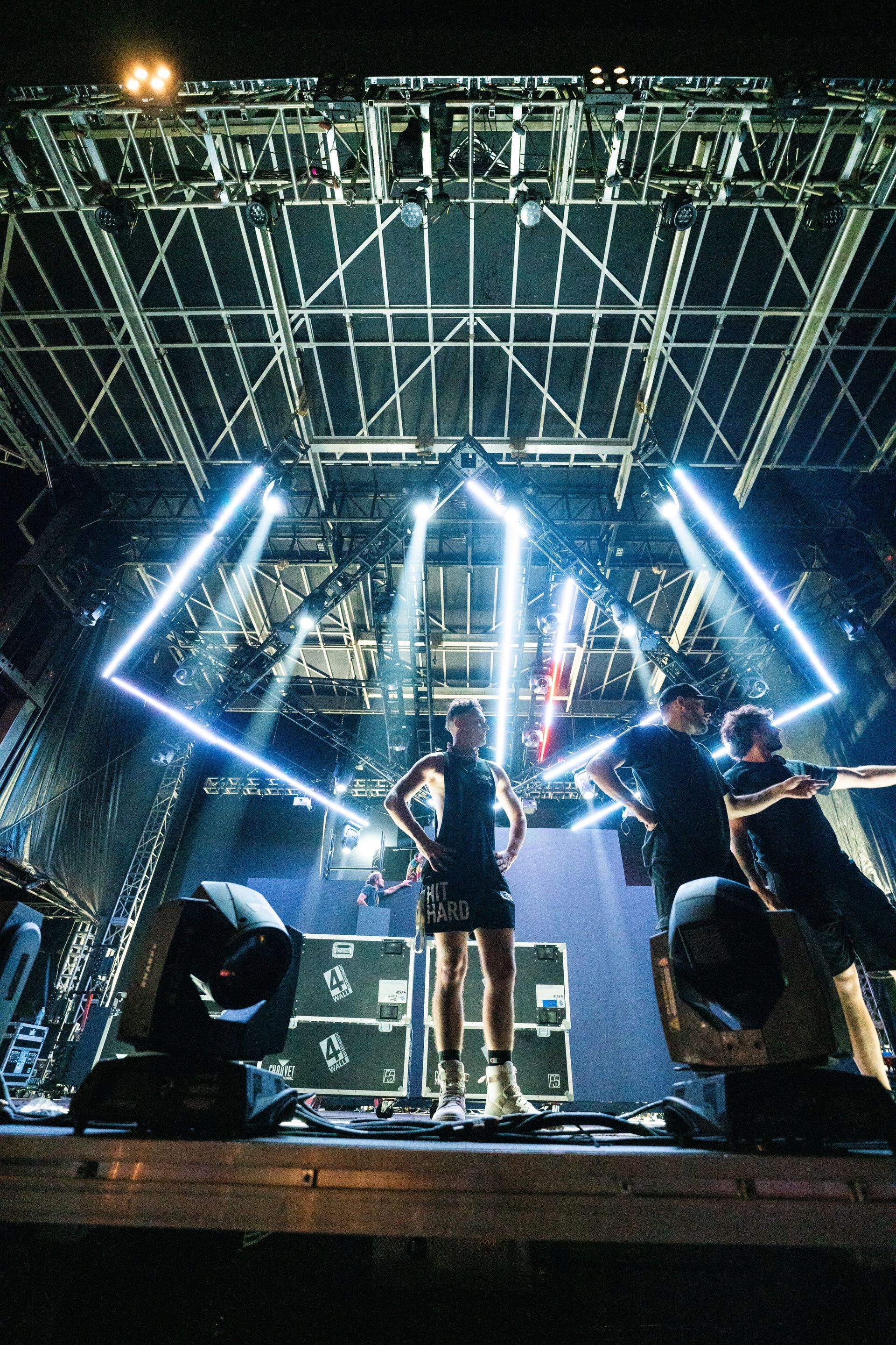 A group of people are standing on a stage in a dark room.