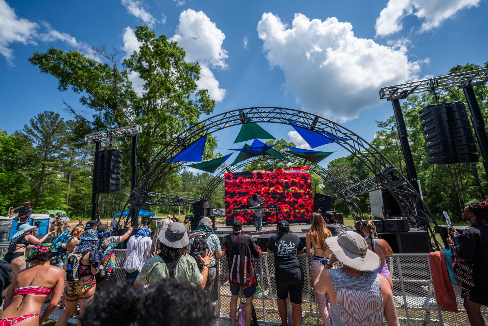 A group of people are standing in front of a stage at a concert.