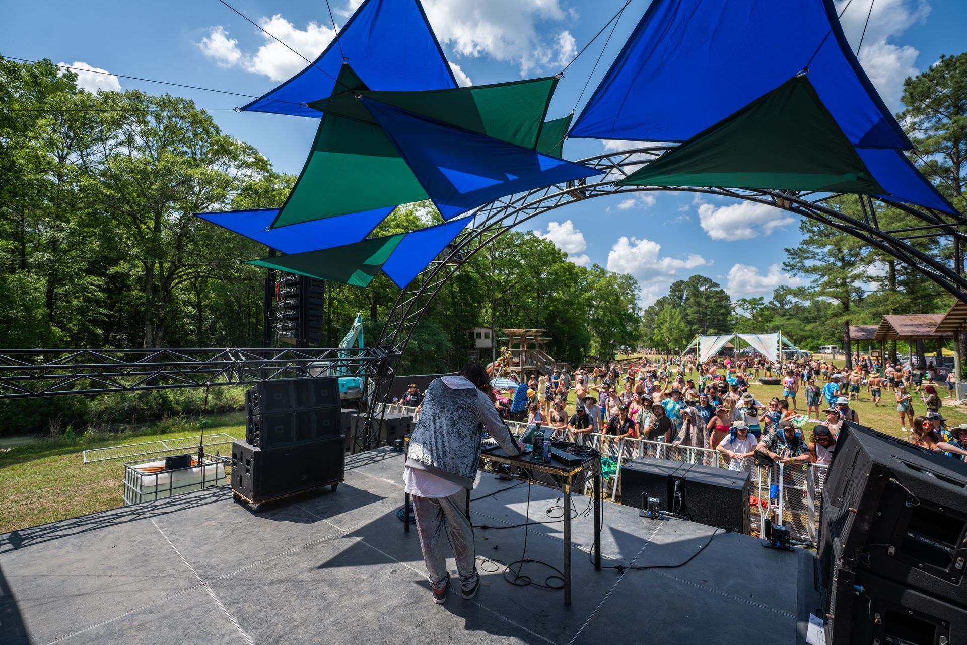 A man is playing a dj set on a stage in front of a crowd.