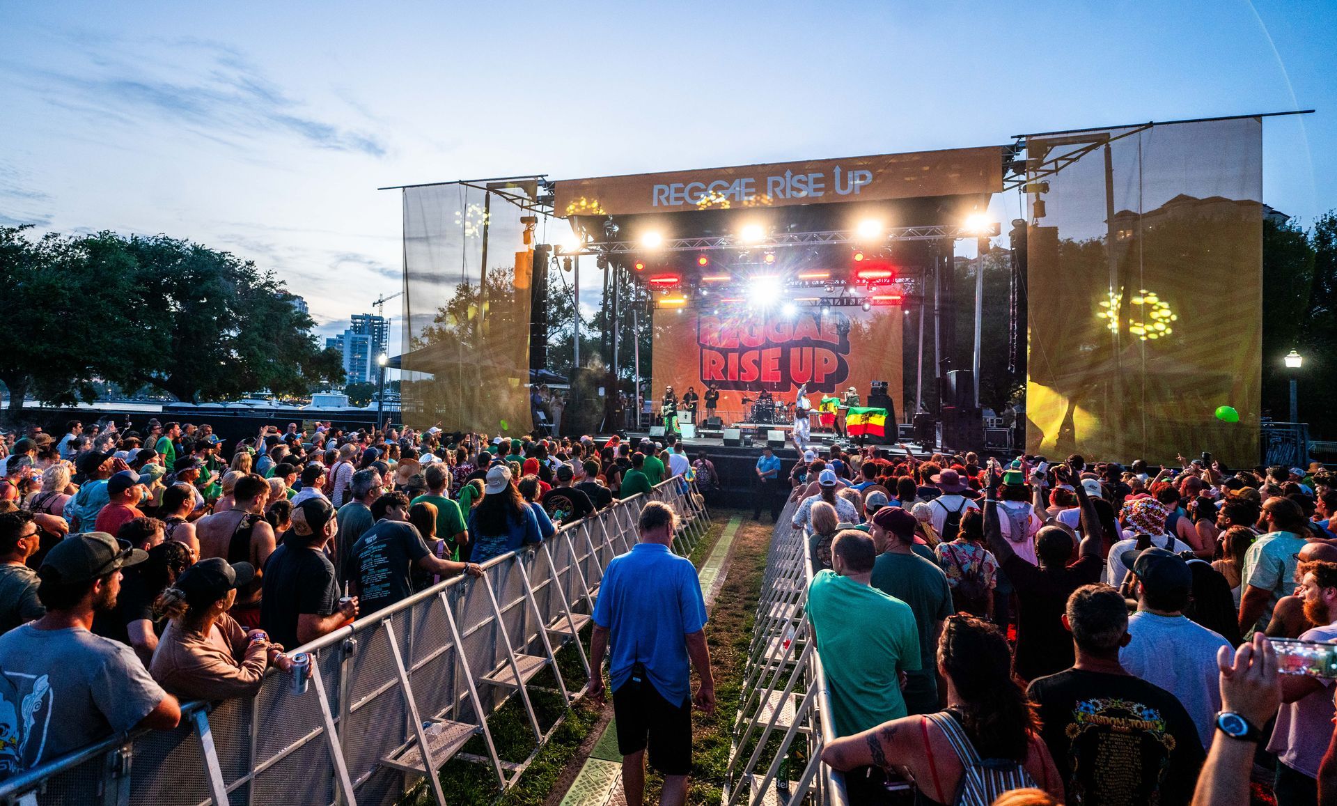A crowd of people are standing in front of a stage at a concert.