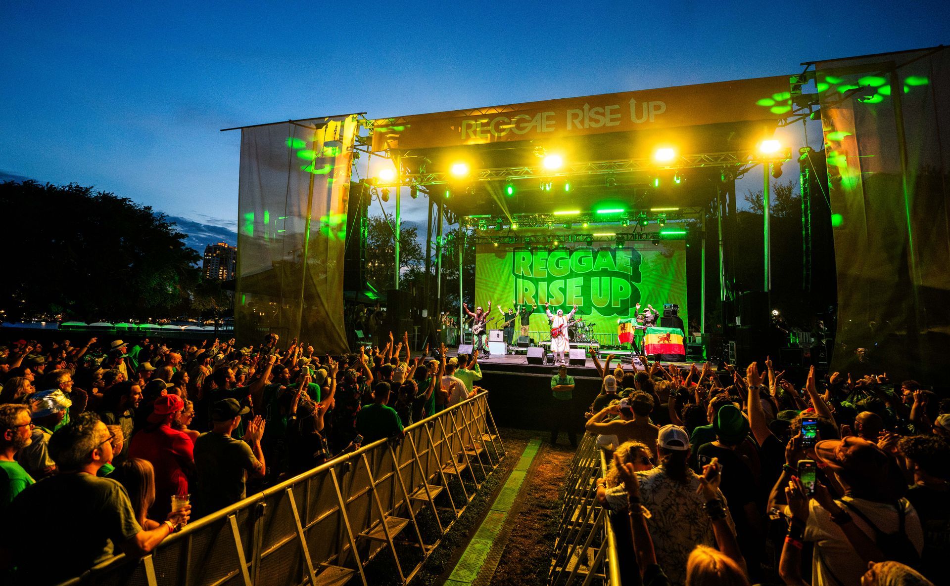 A crowd of people are watching a band on stage at a concert.