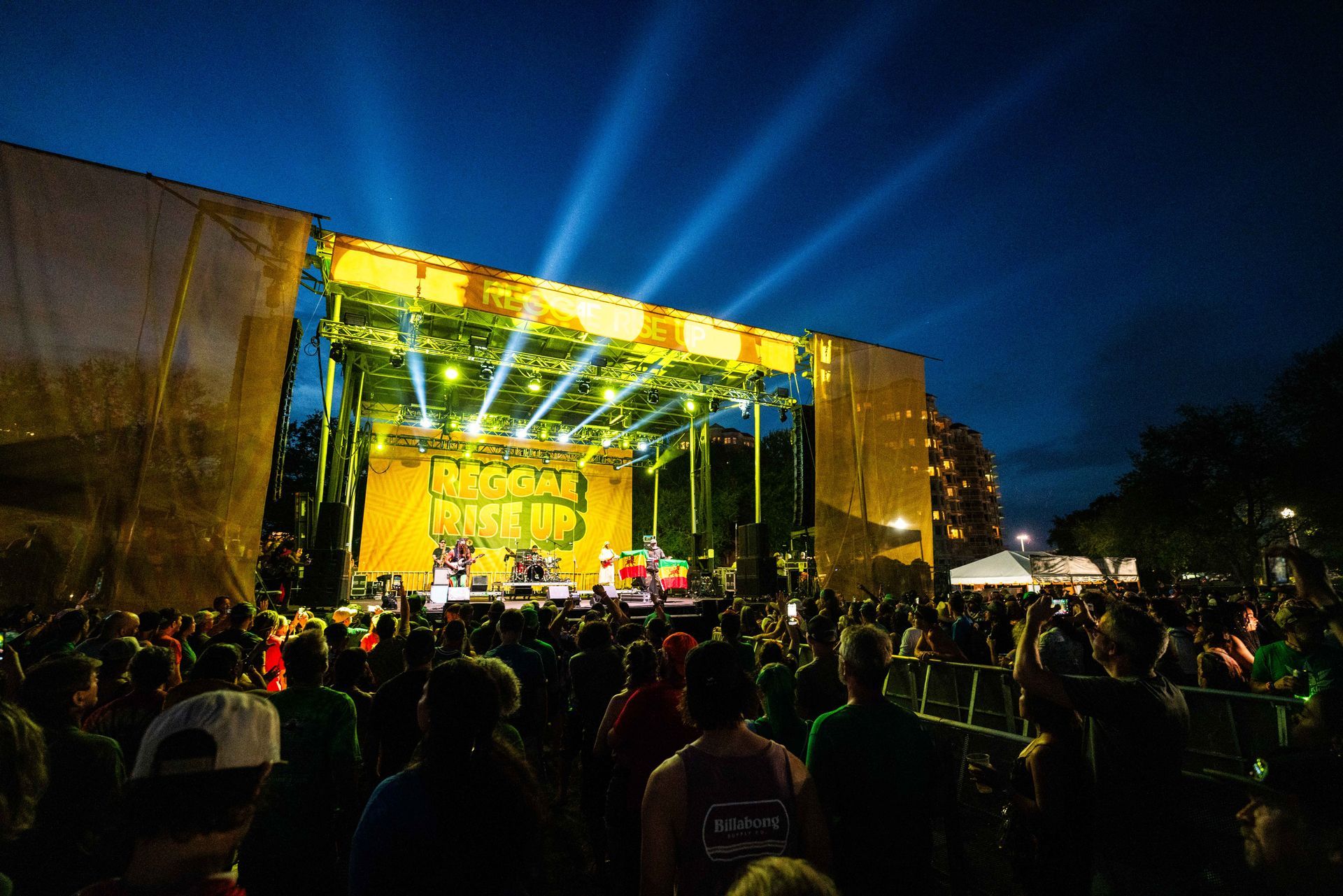 A crowd of people are watching a band on stage at a concert.