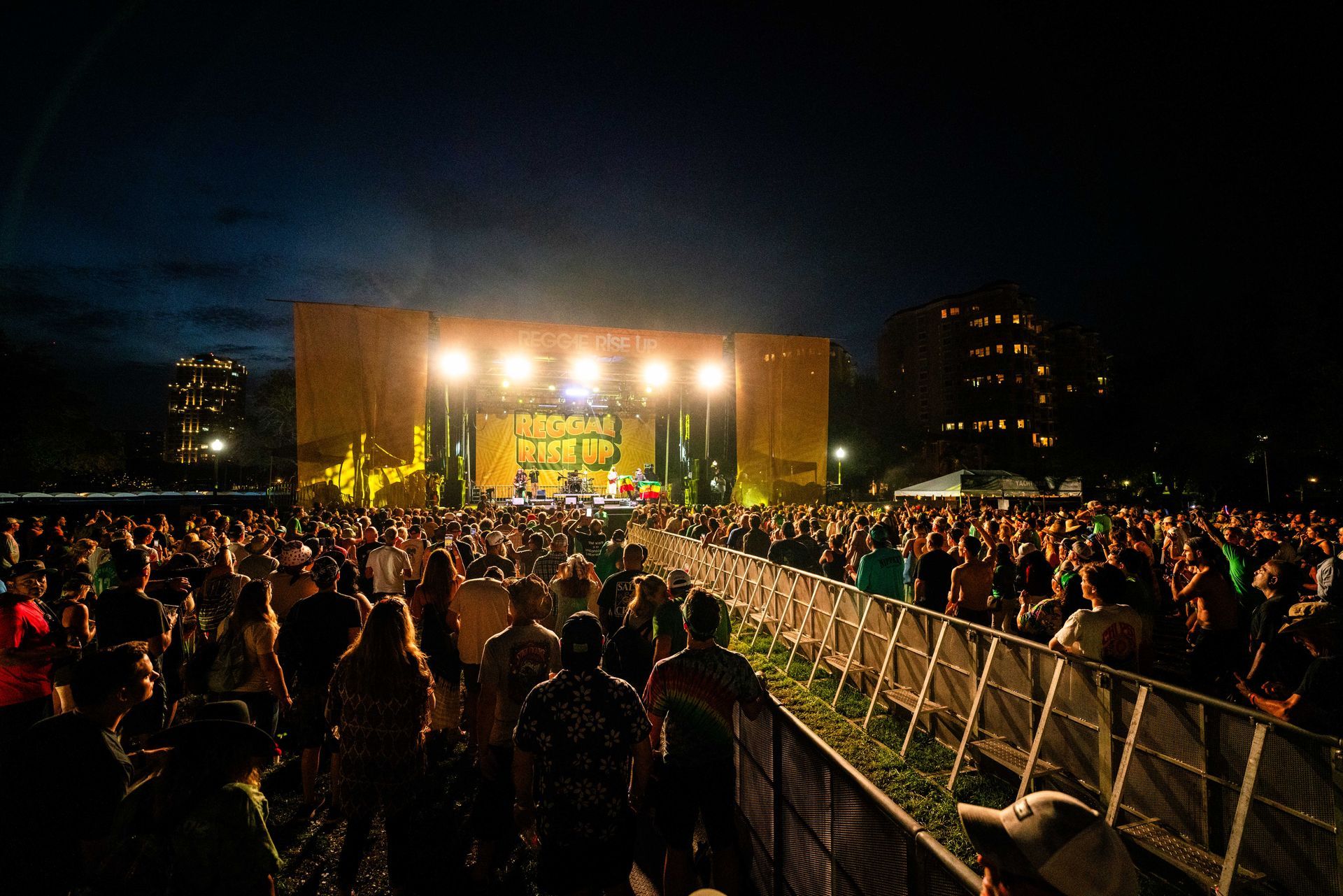 A crowd of people are standing in front of a stage at a concert.