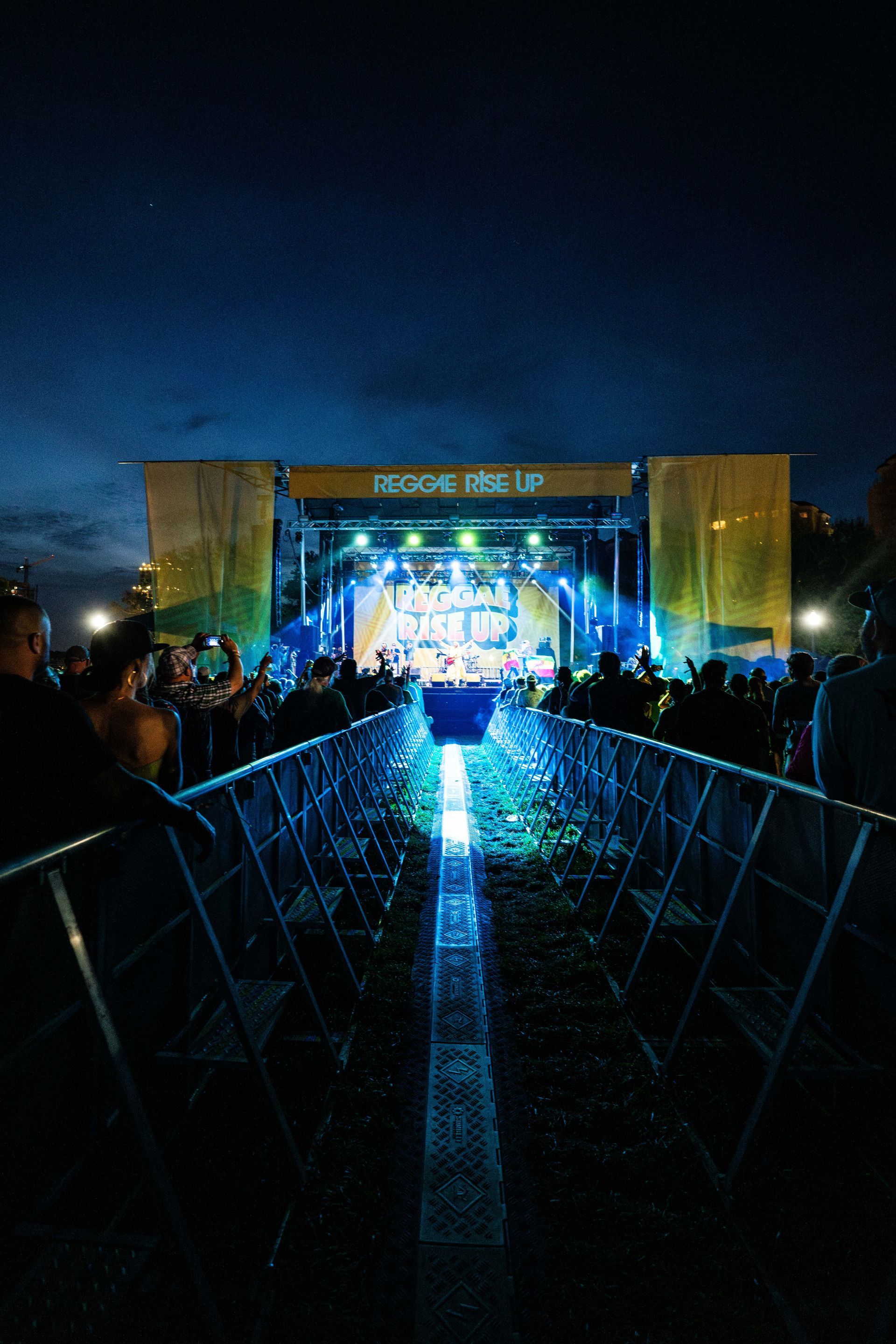 A group of people are standing in front of a stage at a concert.