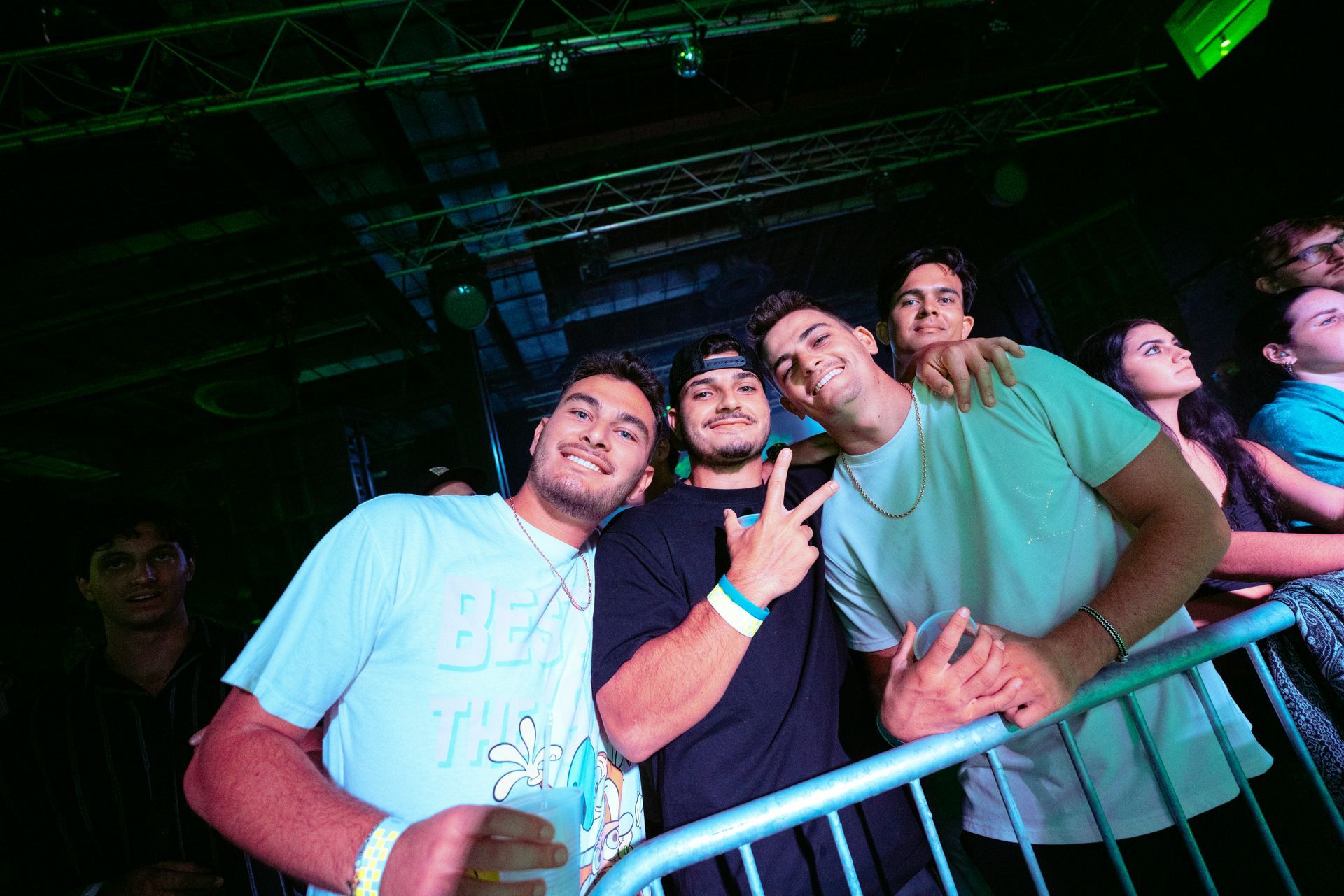 A group of young men are posing for a picture at a concert.