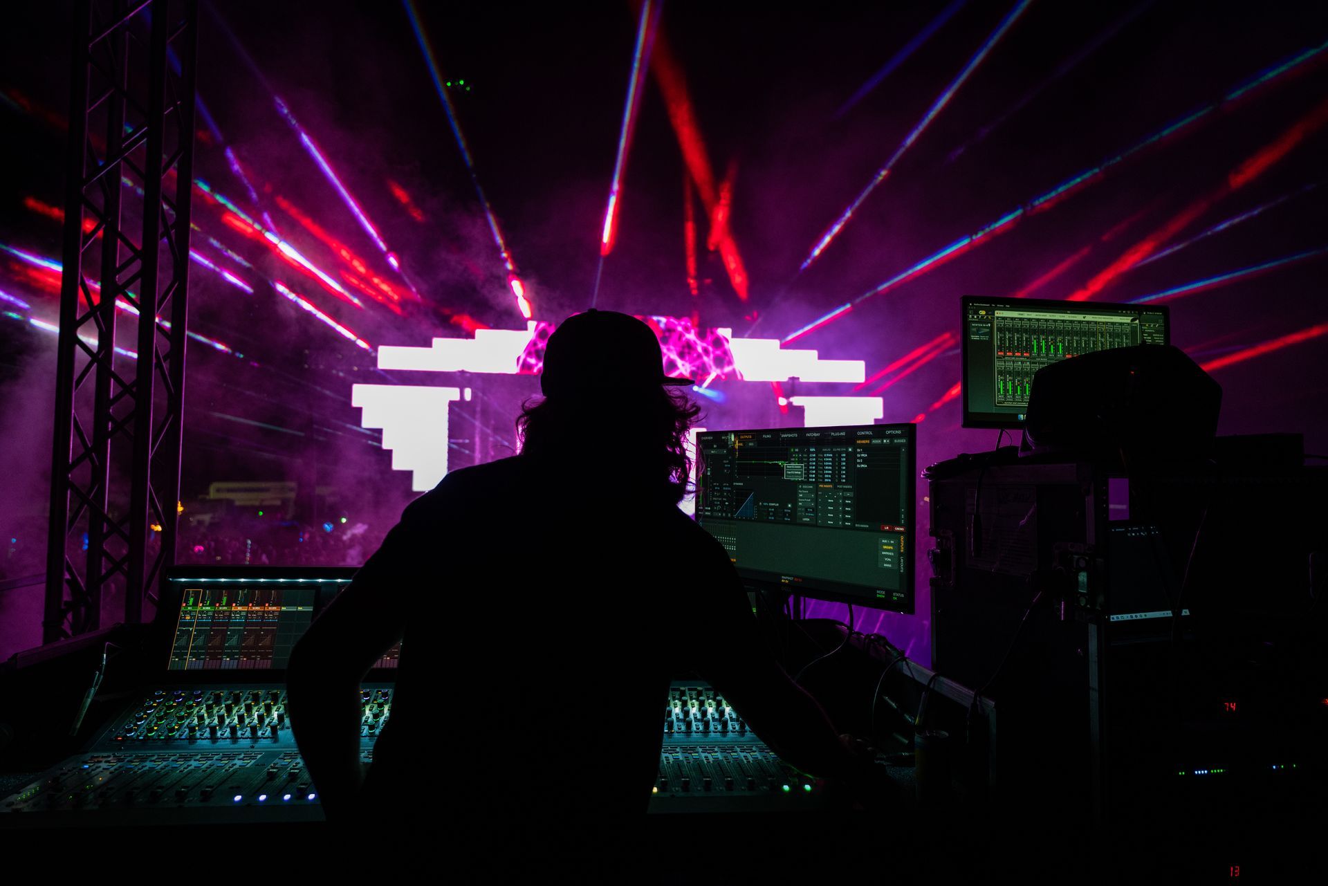 A man is sitting in front of a computer in a dark room.