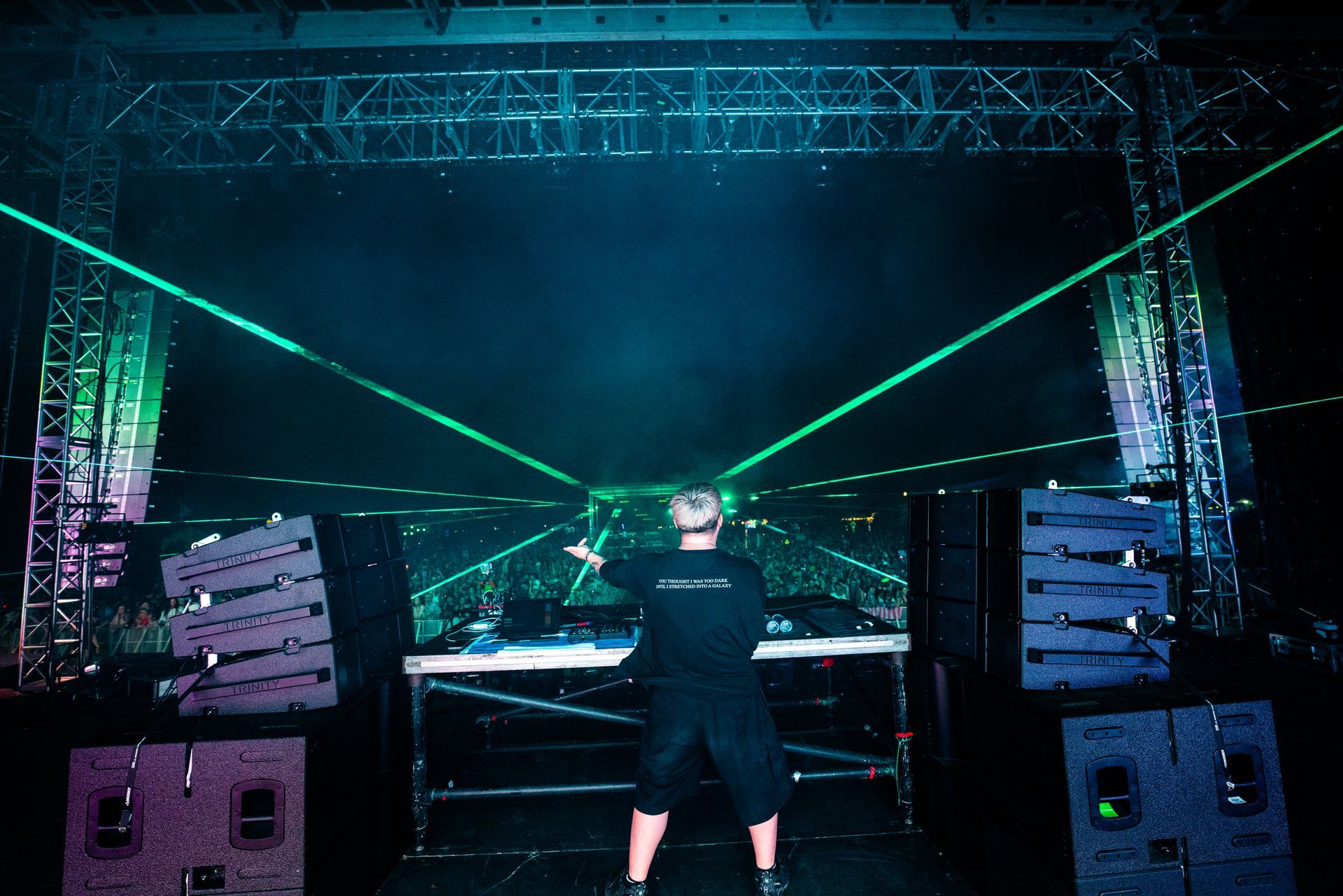 A man is standing in front of a stage with a green light behind him