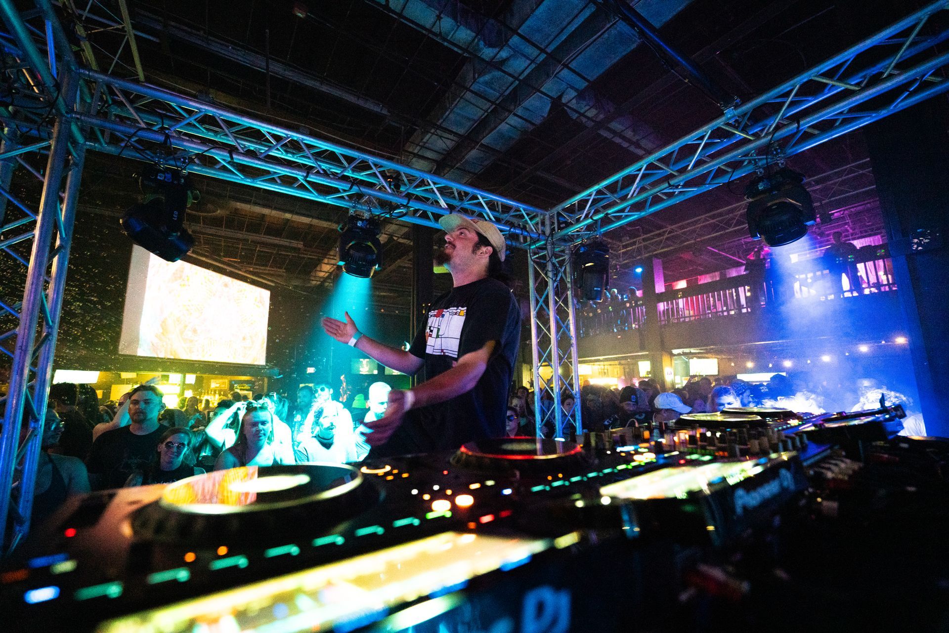 A man is playing a dj set in front of a crowd.