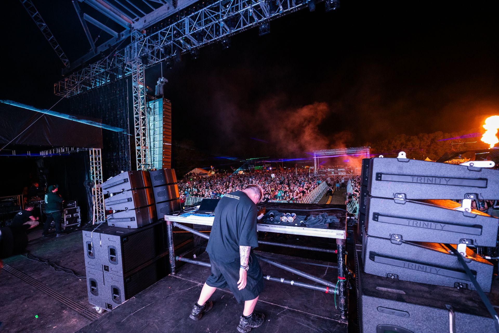 A man is standing on a stage in front of a crowd at a concert.