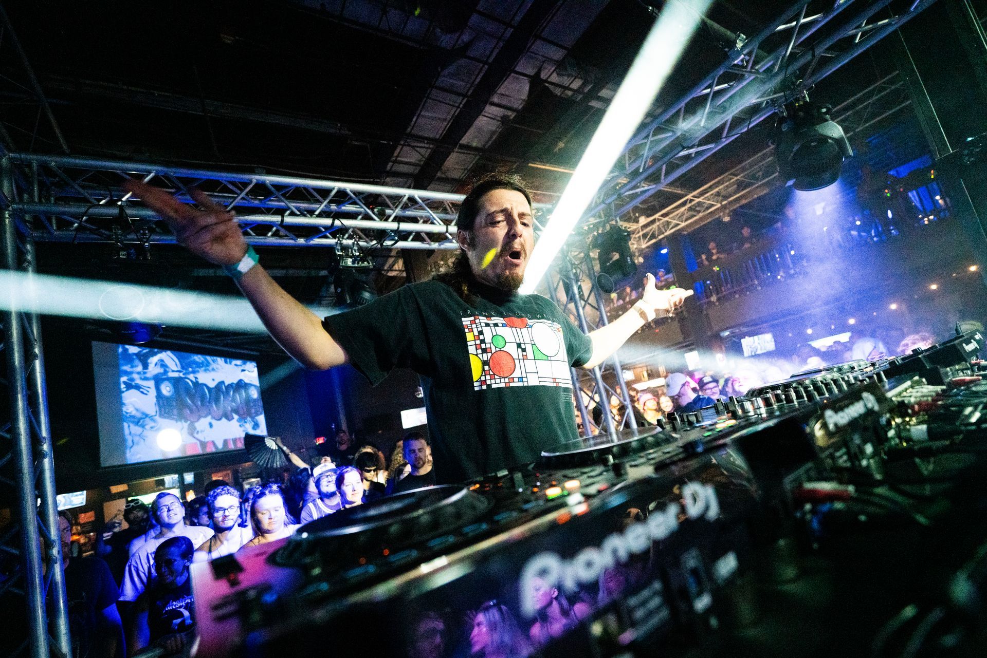 A man is standing in front of a pioneer dj machine