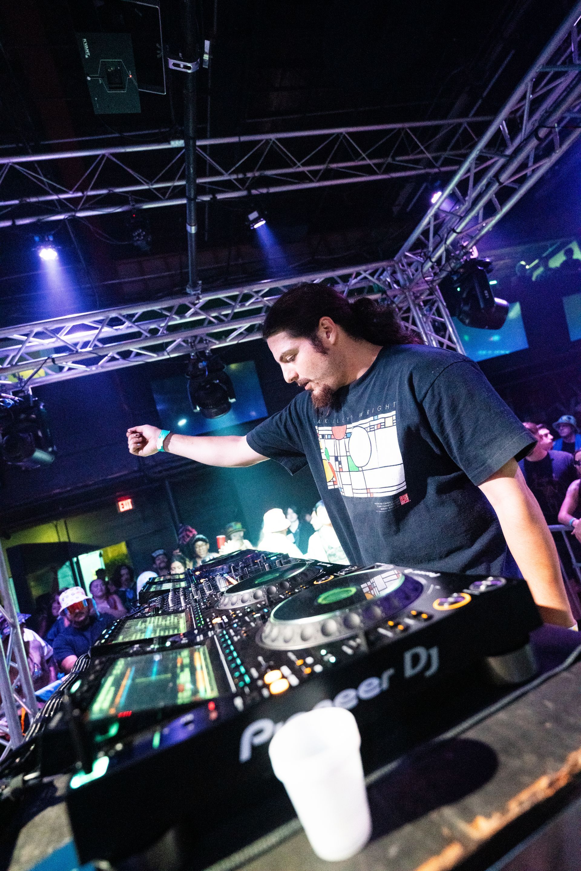 A man is standing in front of a pioneer dj machine