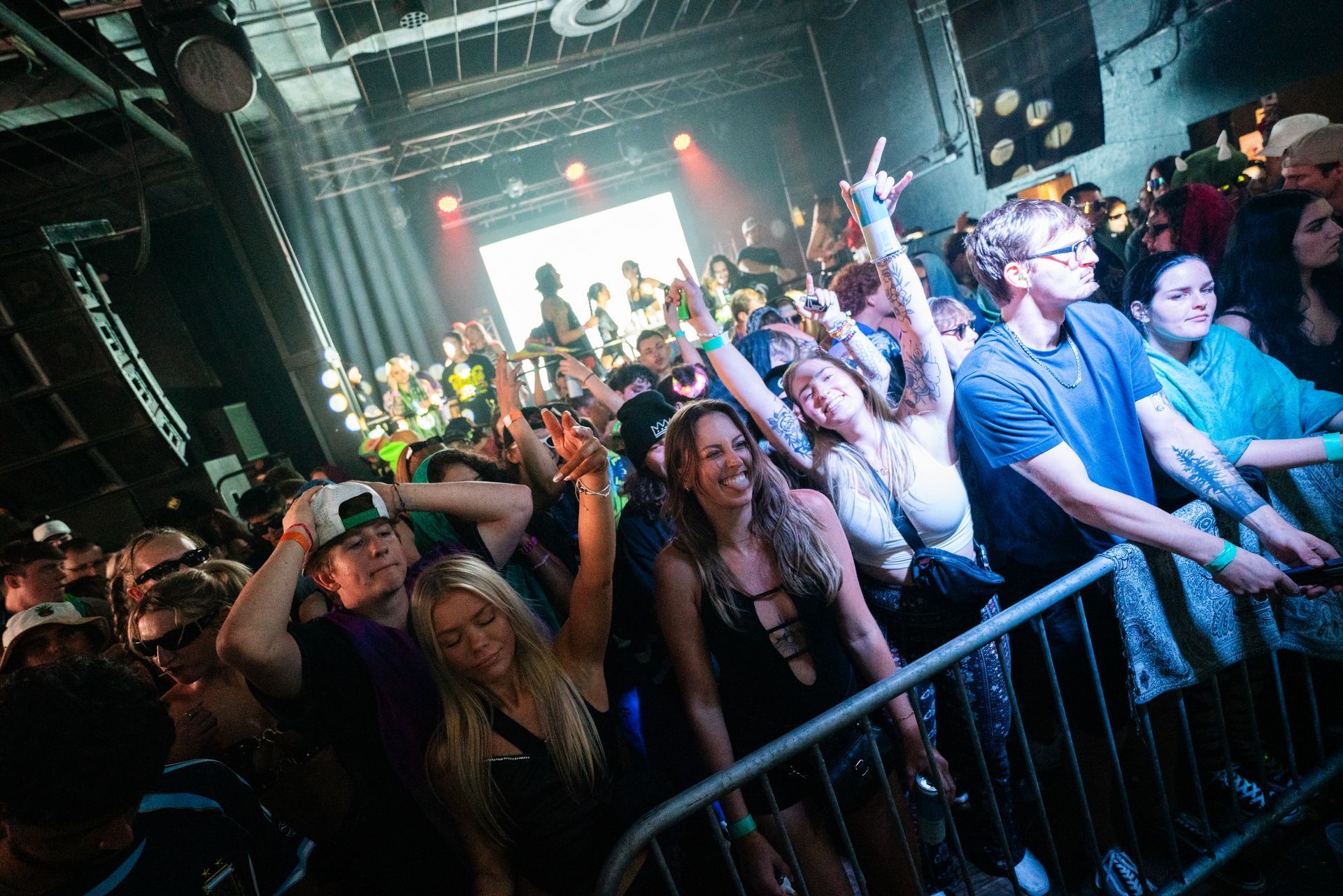 A crowd of people are standing in front of a stage at a concert.