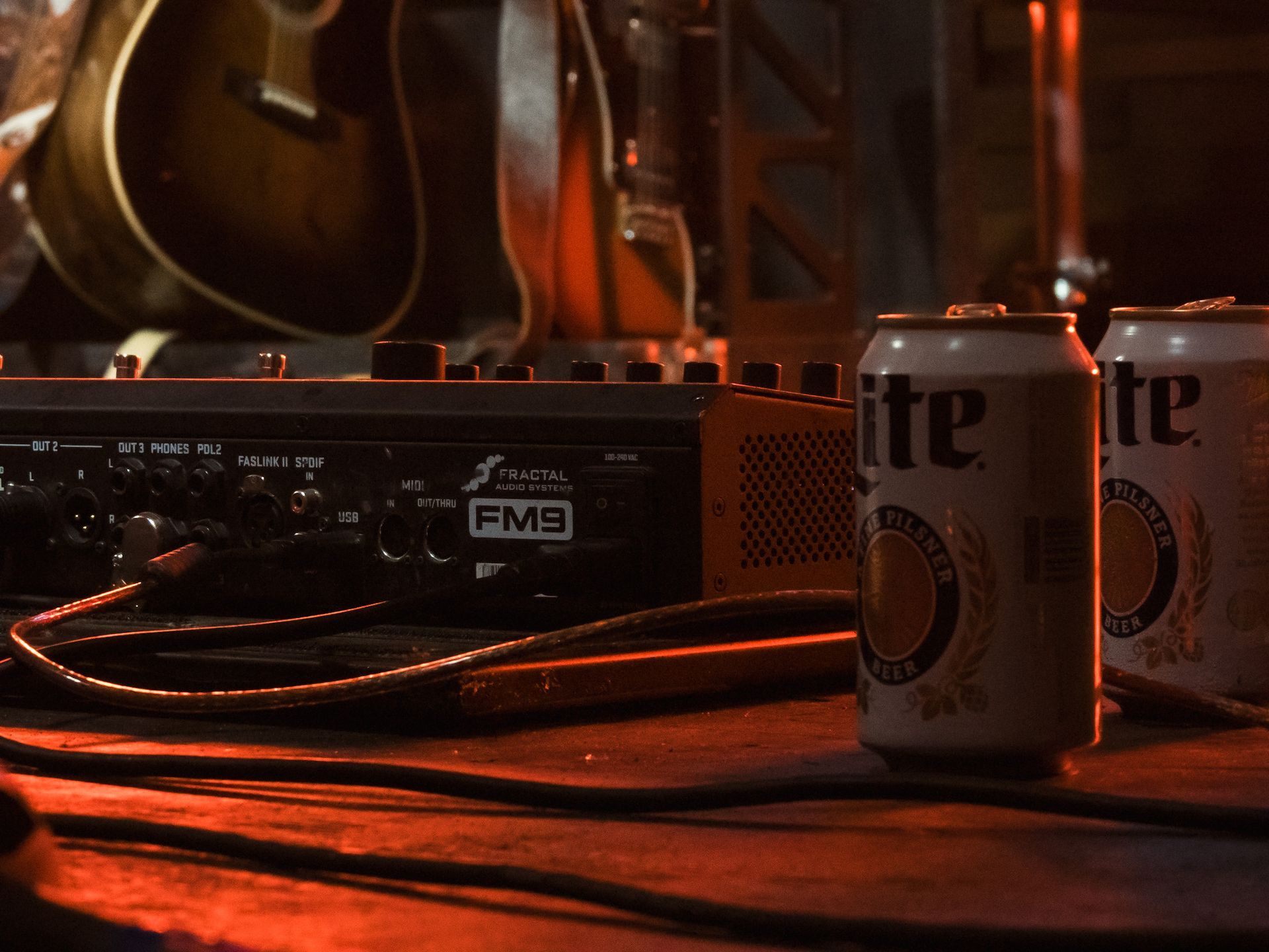 Two cans of lite beer sit on a wooden table