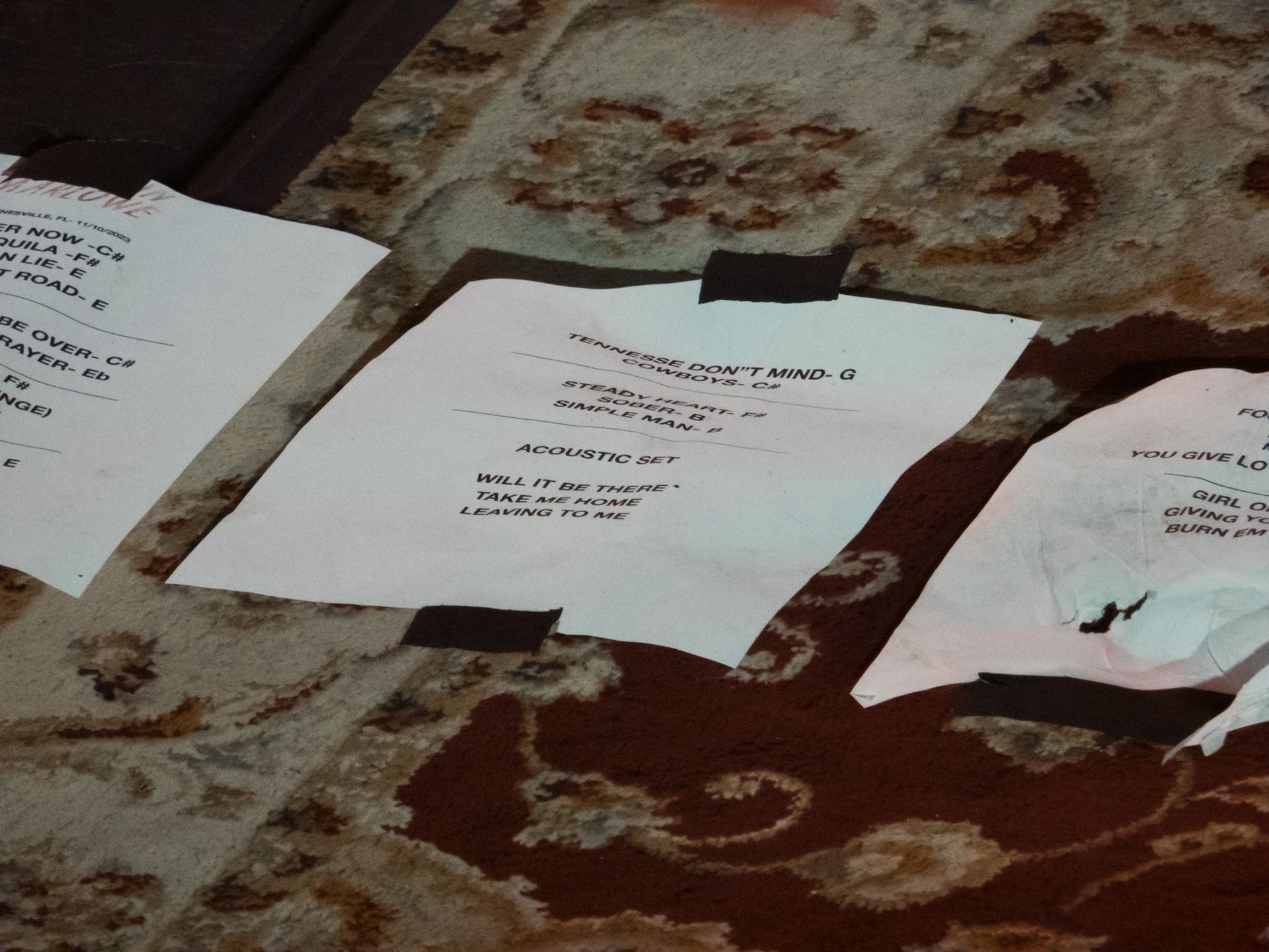 Several pieces of paper are taped together on a rug
