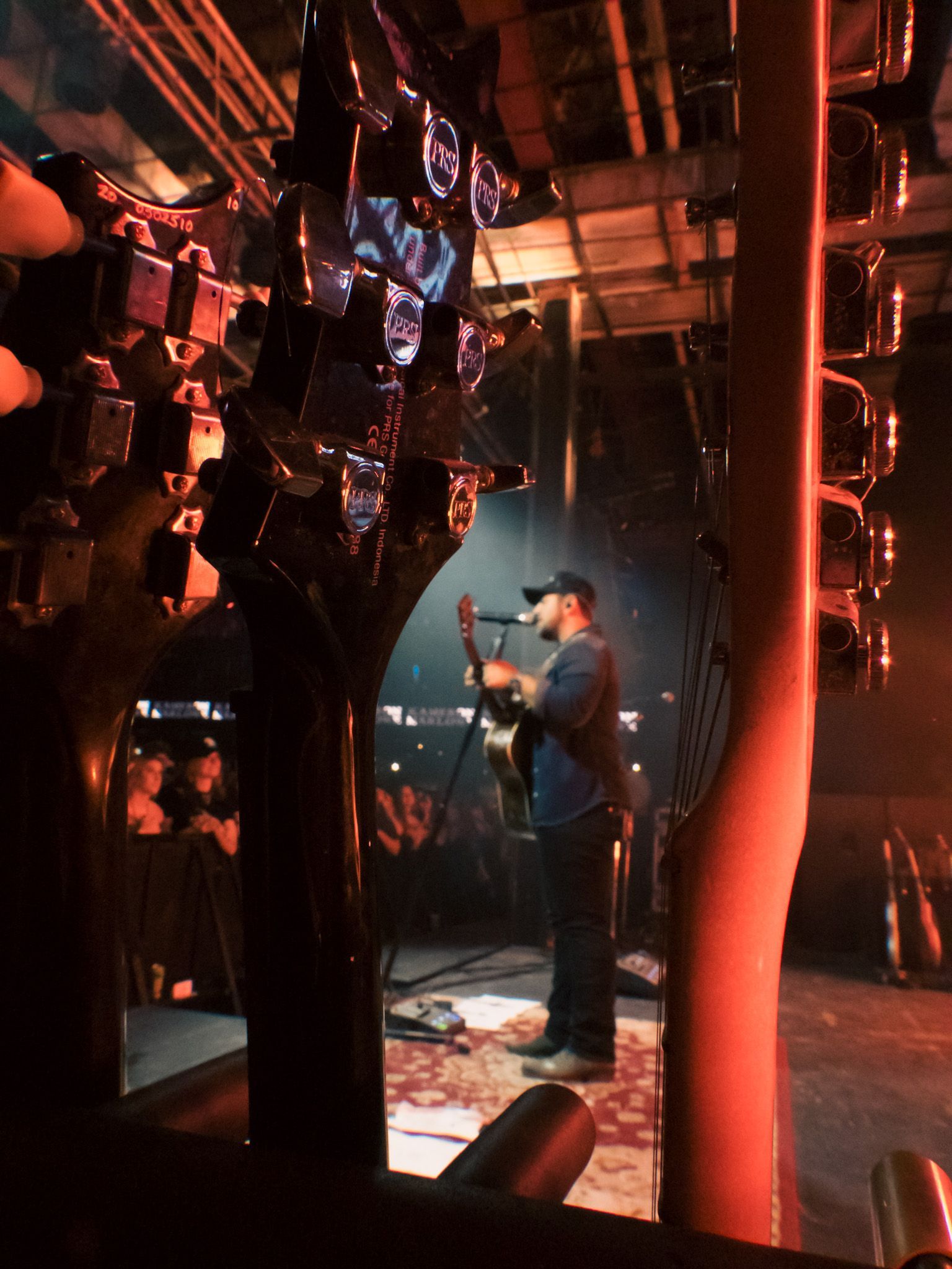 A man singing into a microphone while playing a guitar