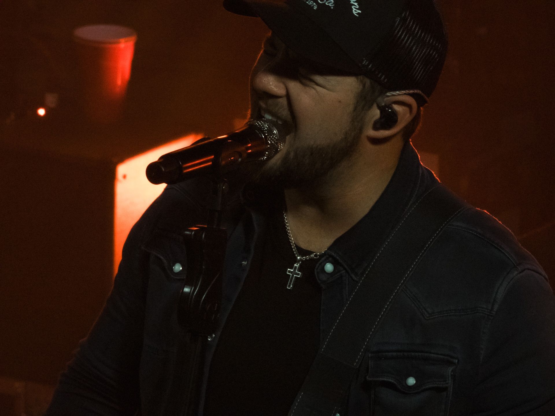 A man singing into a microphone in a dark room