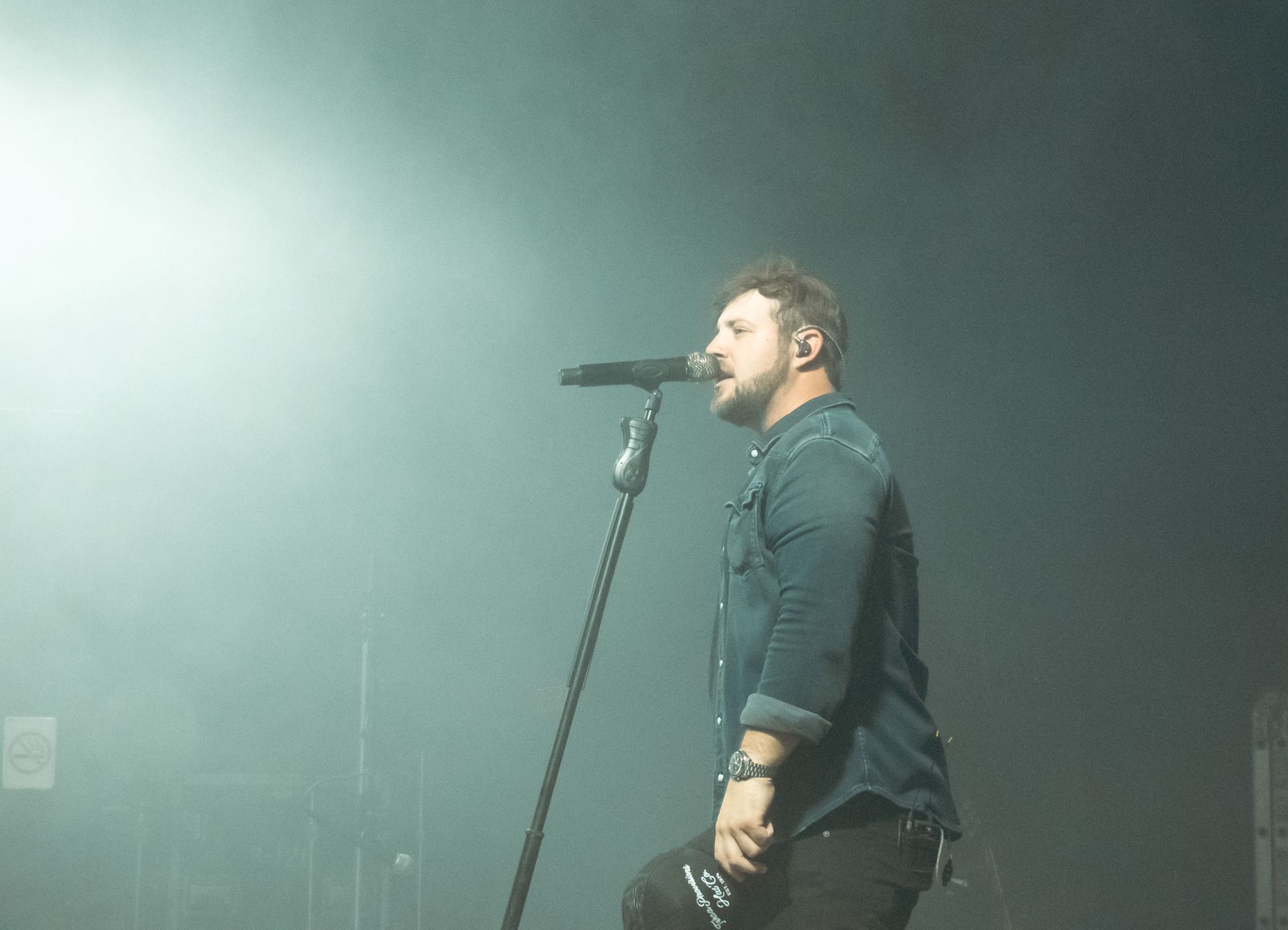 A man is singing into a microphone on a stage.