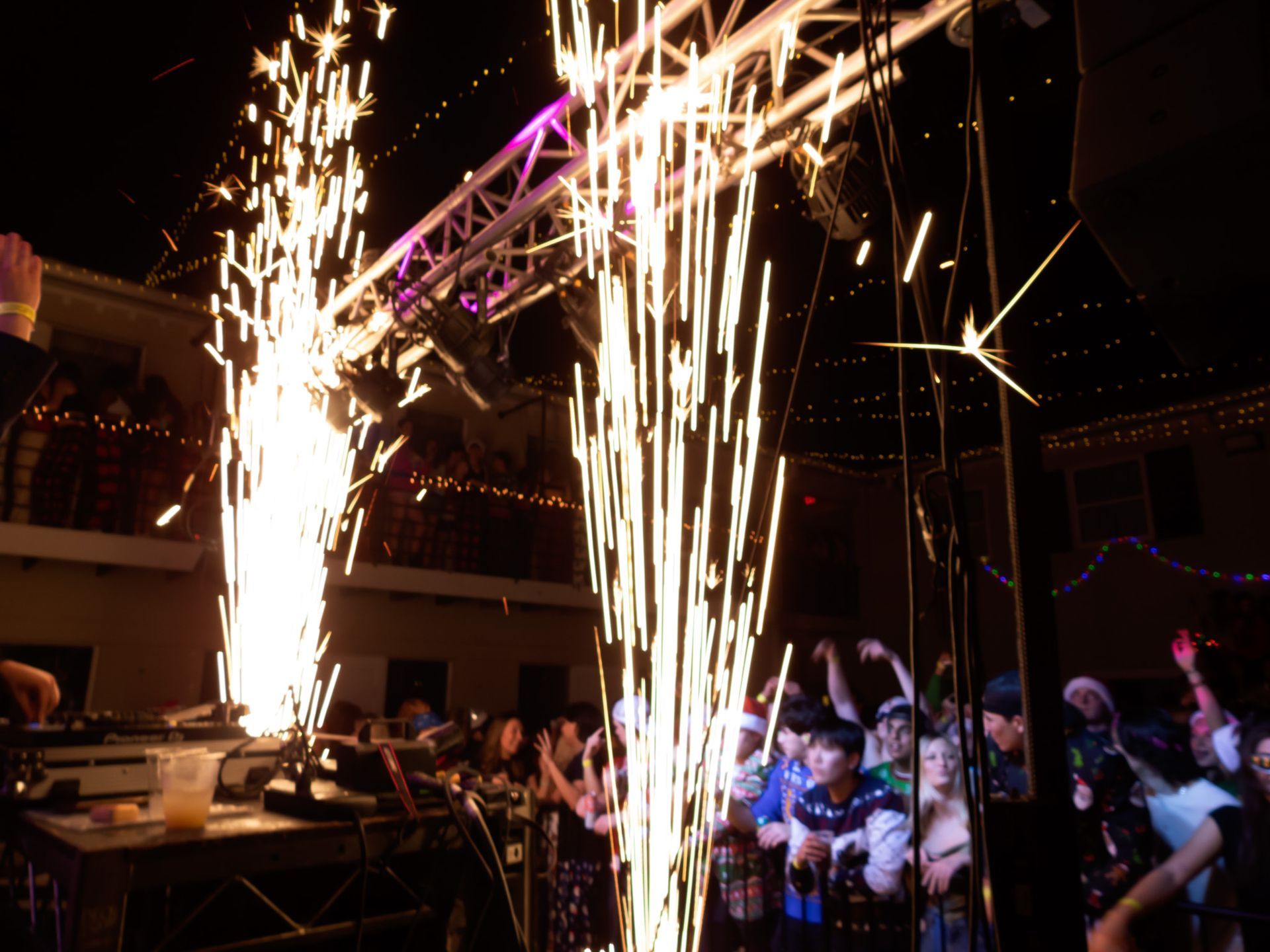 A crowd of people watching a fireworks display at a party