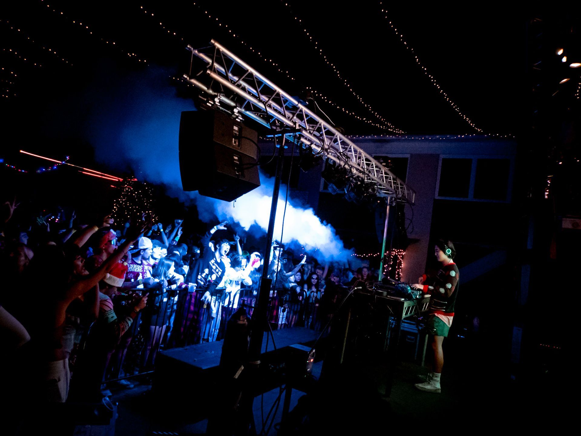A group of people are standing in front of a stage at a concert.