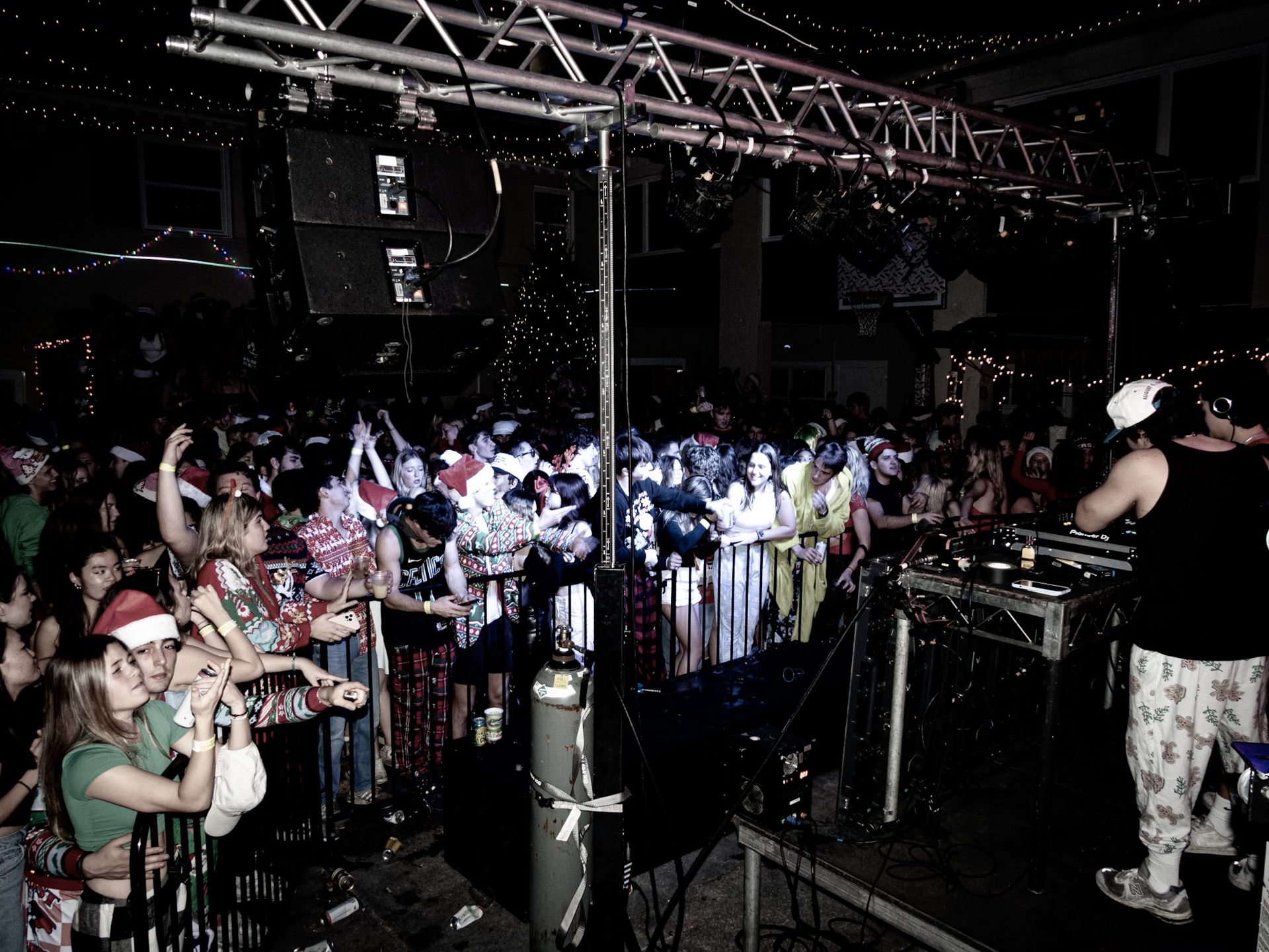 A crowd of people are watching a dj perform in front of them