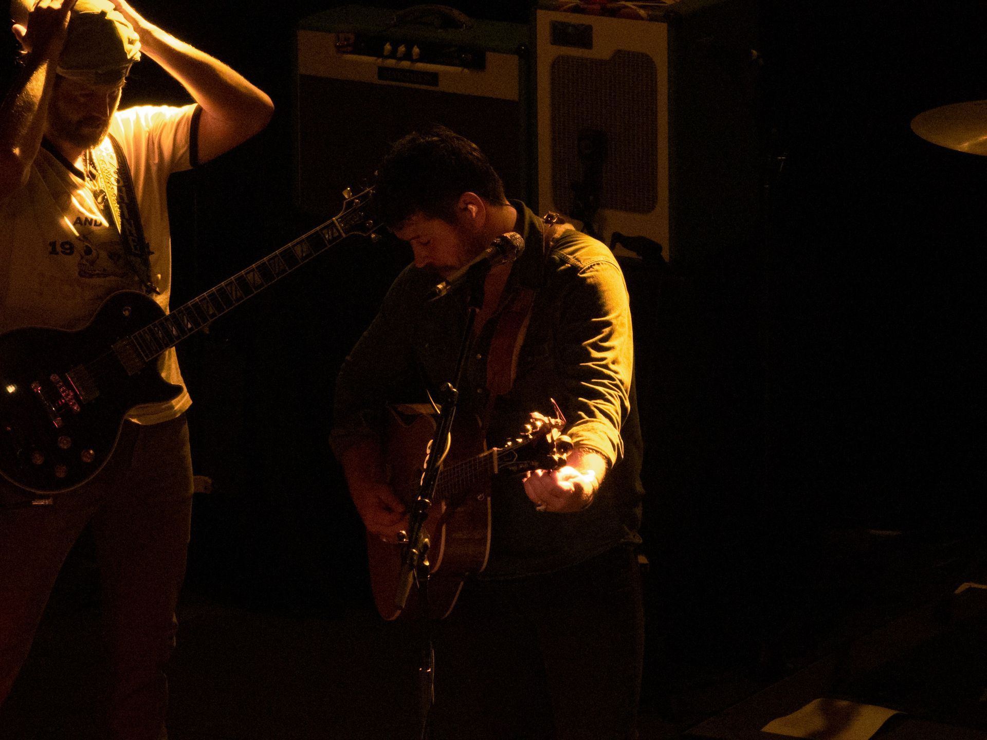 A man playing a guitar in a dark room