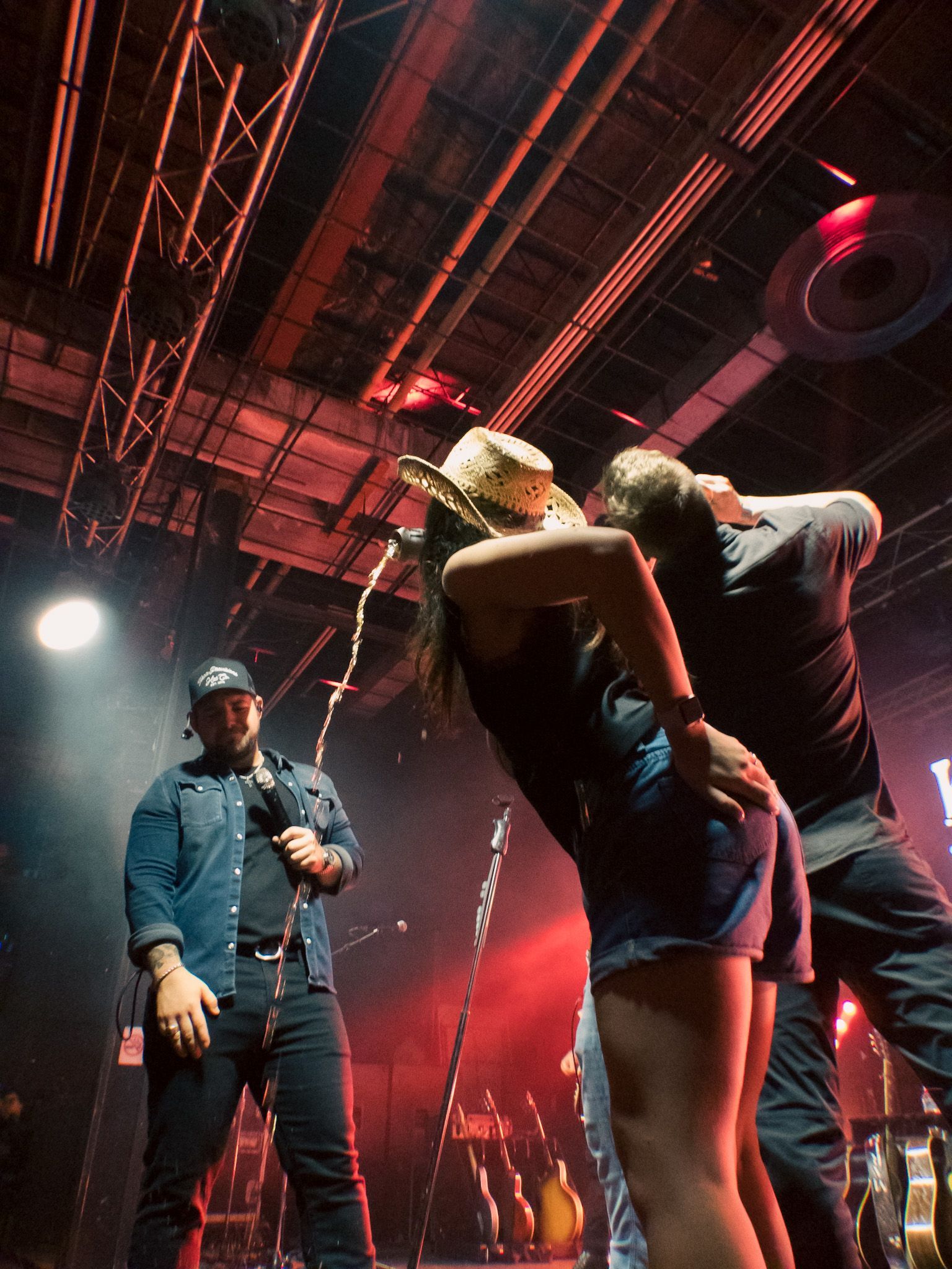 A group of people are standing on a stage with a man holding a microphone