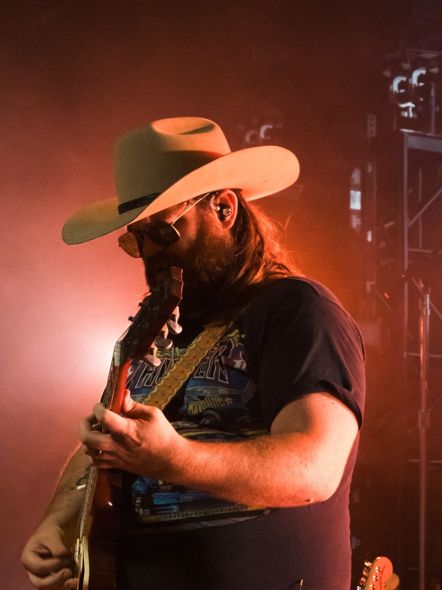 A man in a cowboy hat is playing a guitar