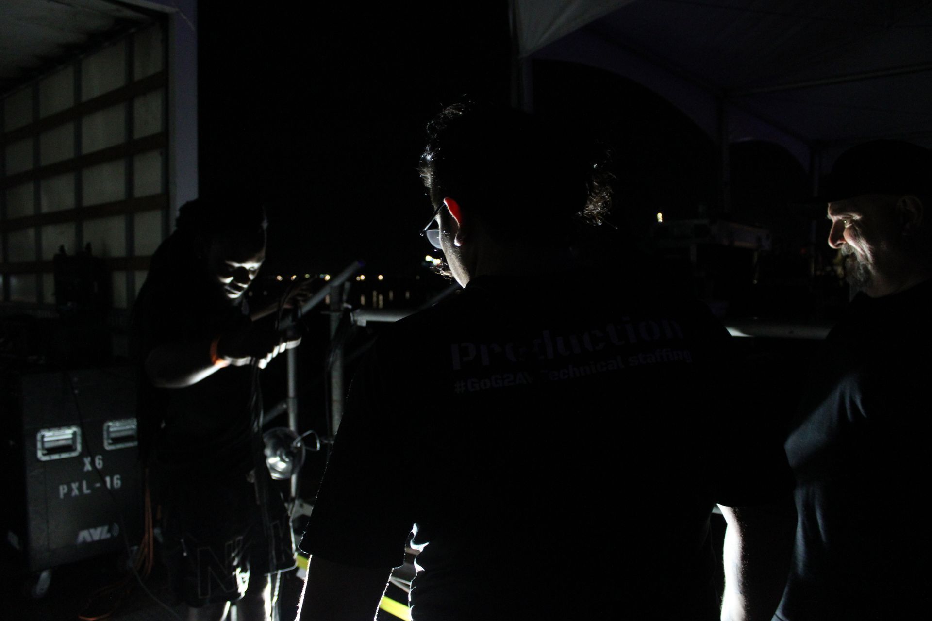 A group of people are standing in a dark room.