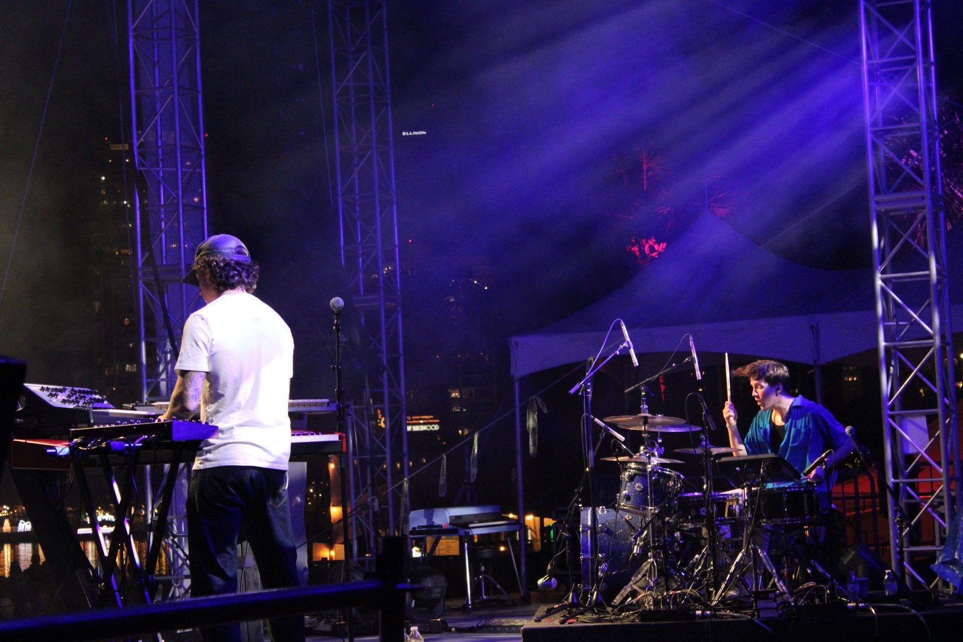 A man playing a keyboard and a man playing drums on a stage