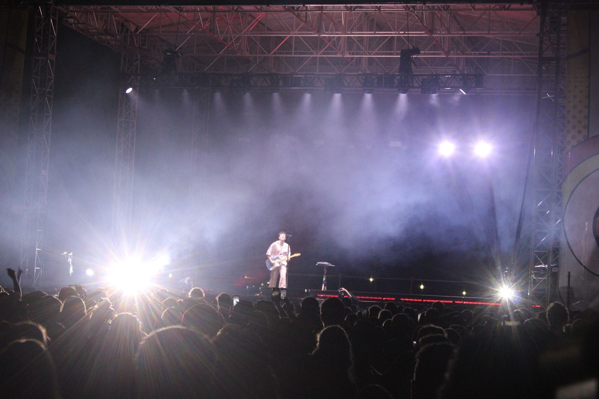 A man is playing a guitar on a stage in front of a crowd.