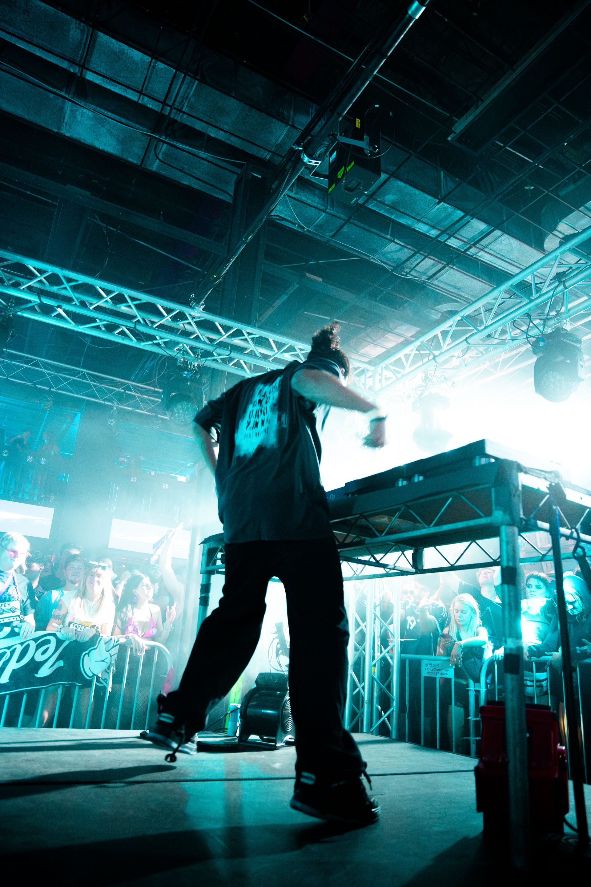 A man is standing on a stage in front of a crowd in a dark room.