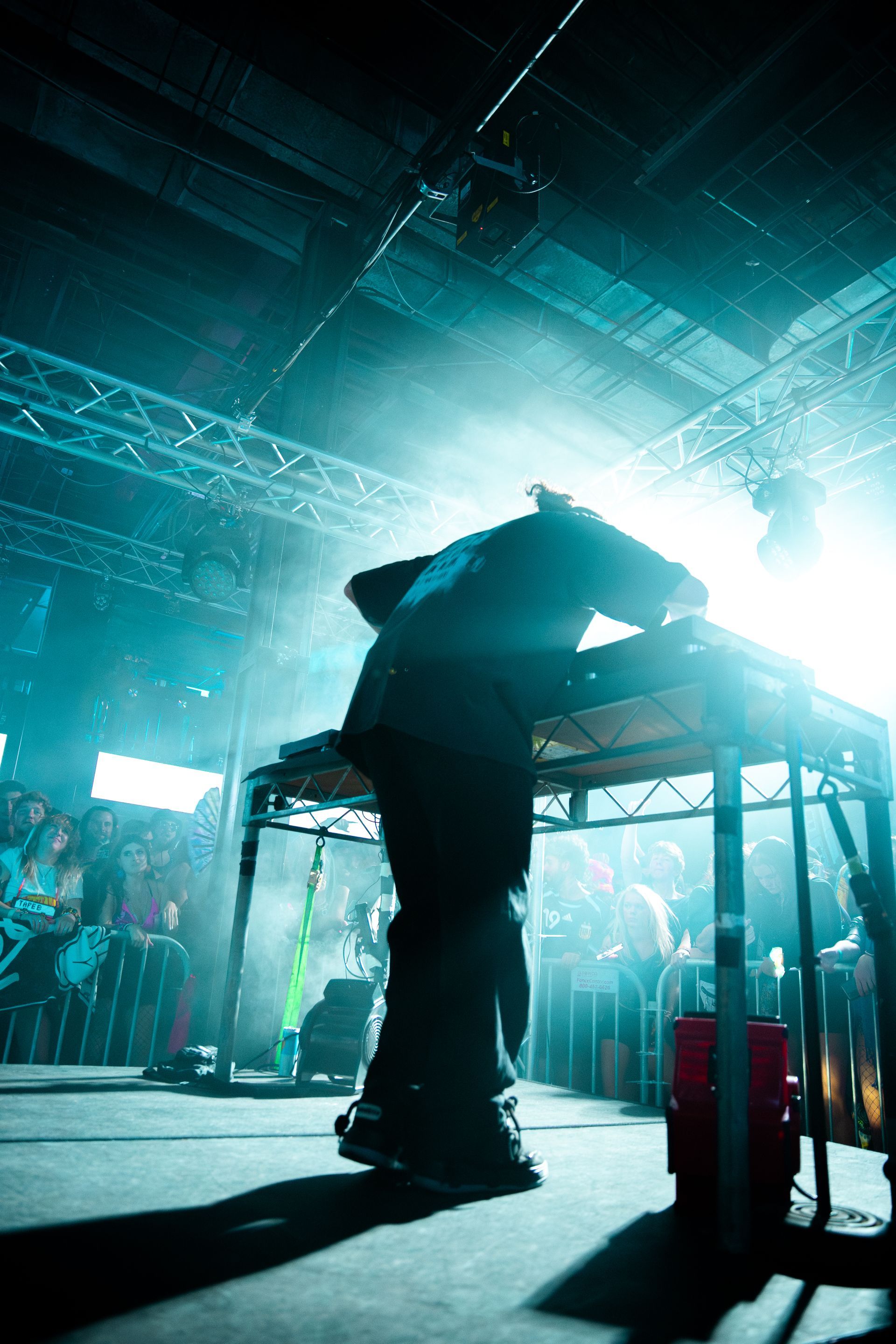 A man is standing on a stage in front of a crowd in a dark room.