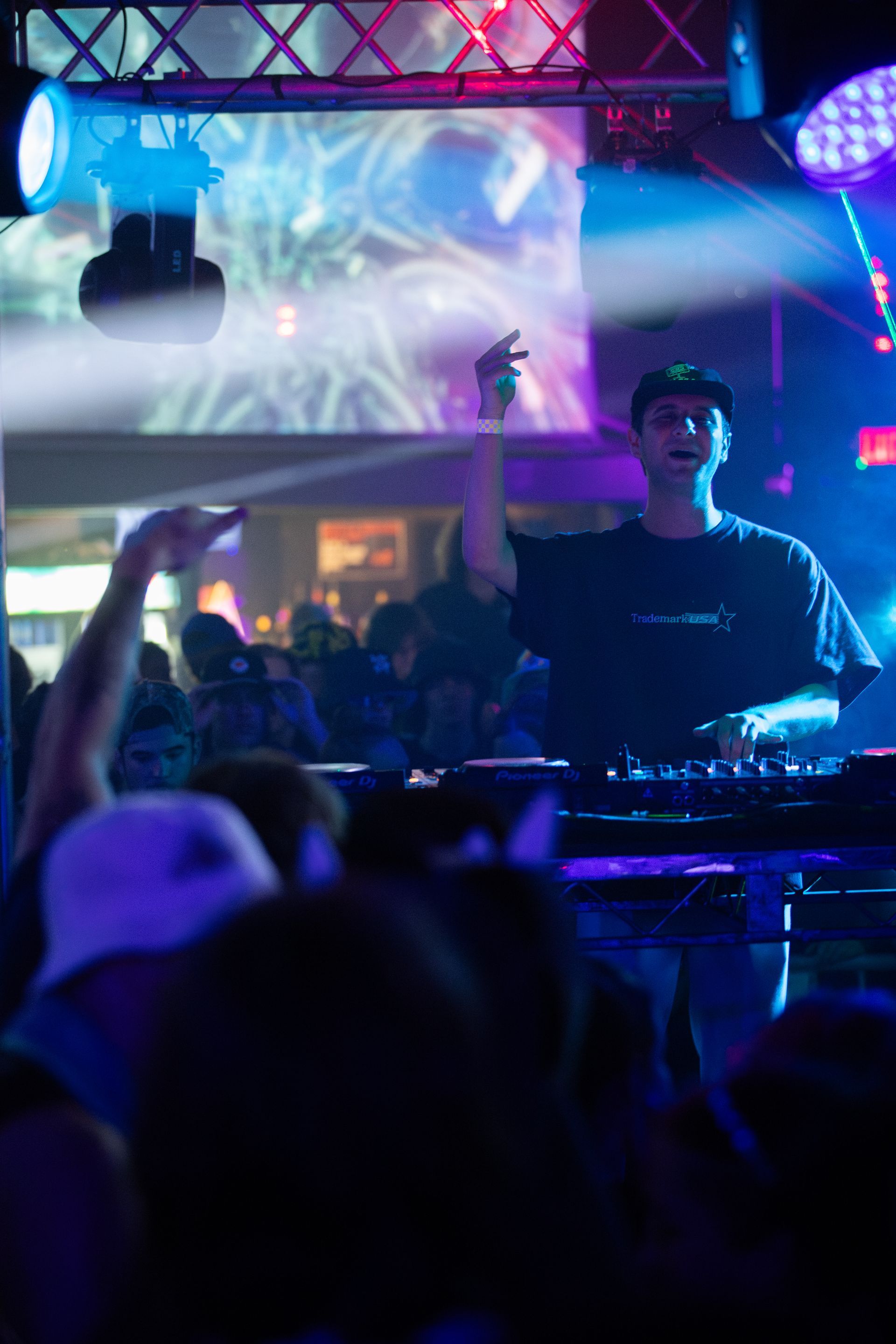 A man is playing a dj set in front of a crowd at a concert.