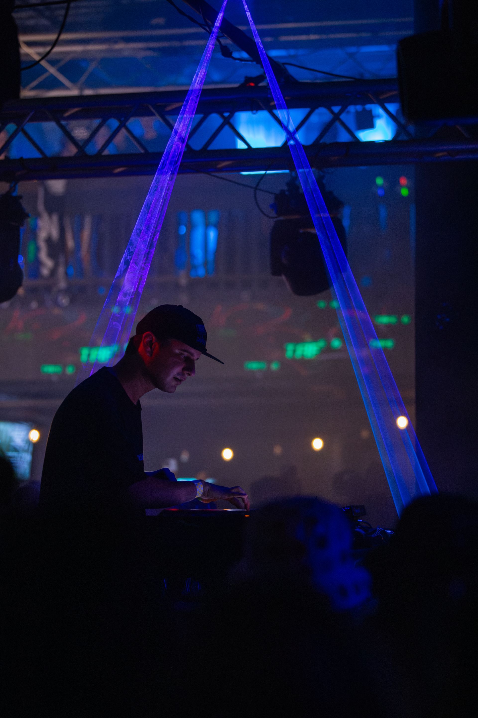A man is playing a dj set in a dark room.
