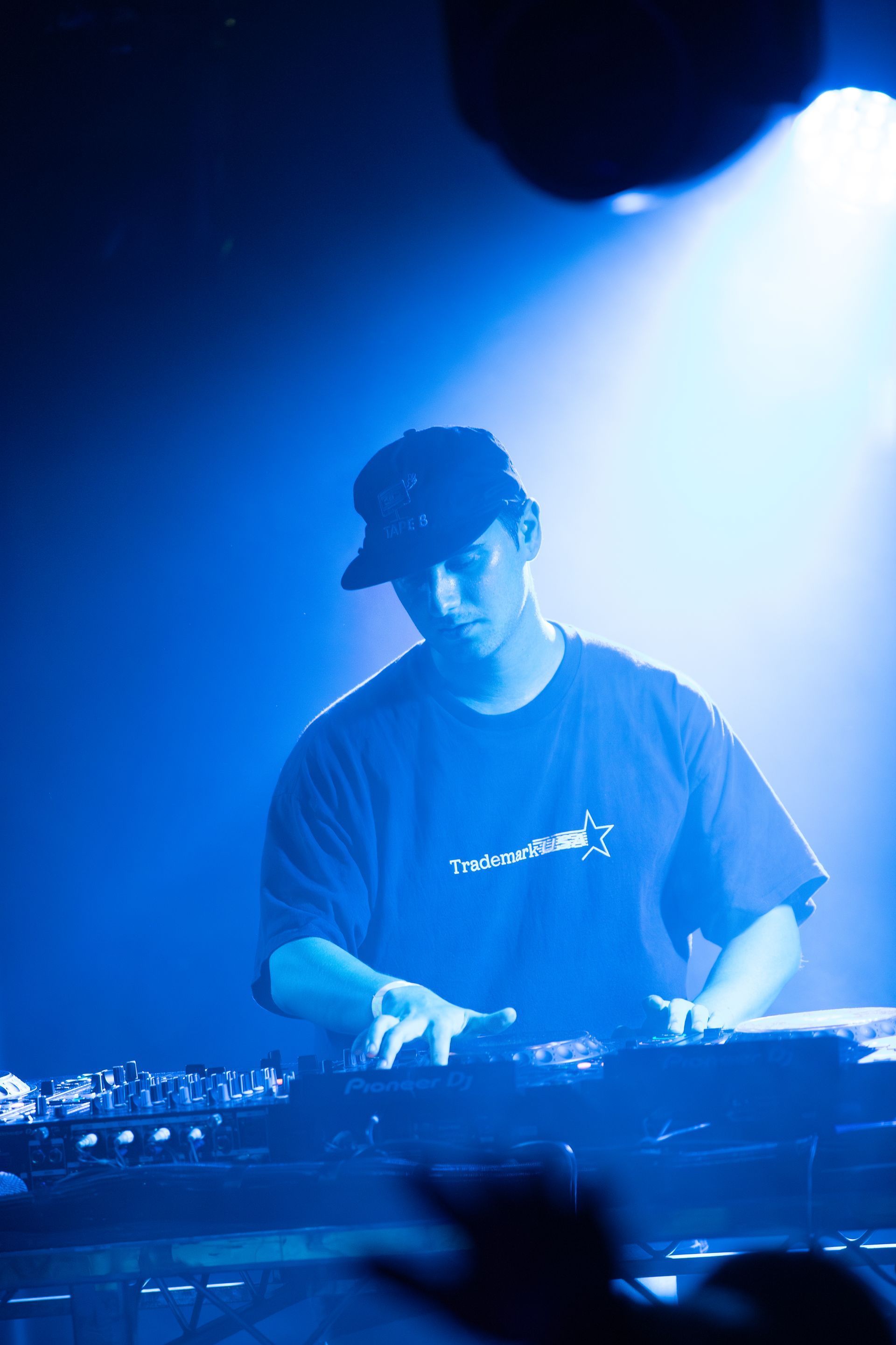 A man is playing a keyboard in a dark room with blue lights.