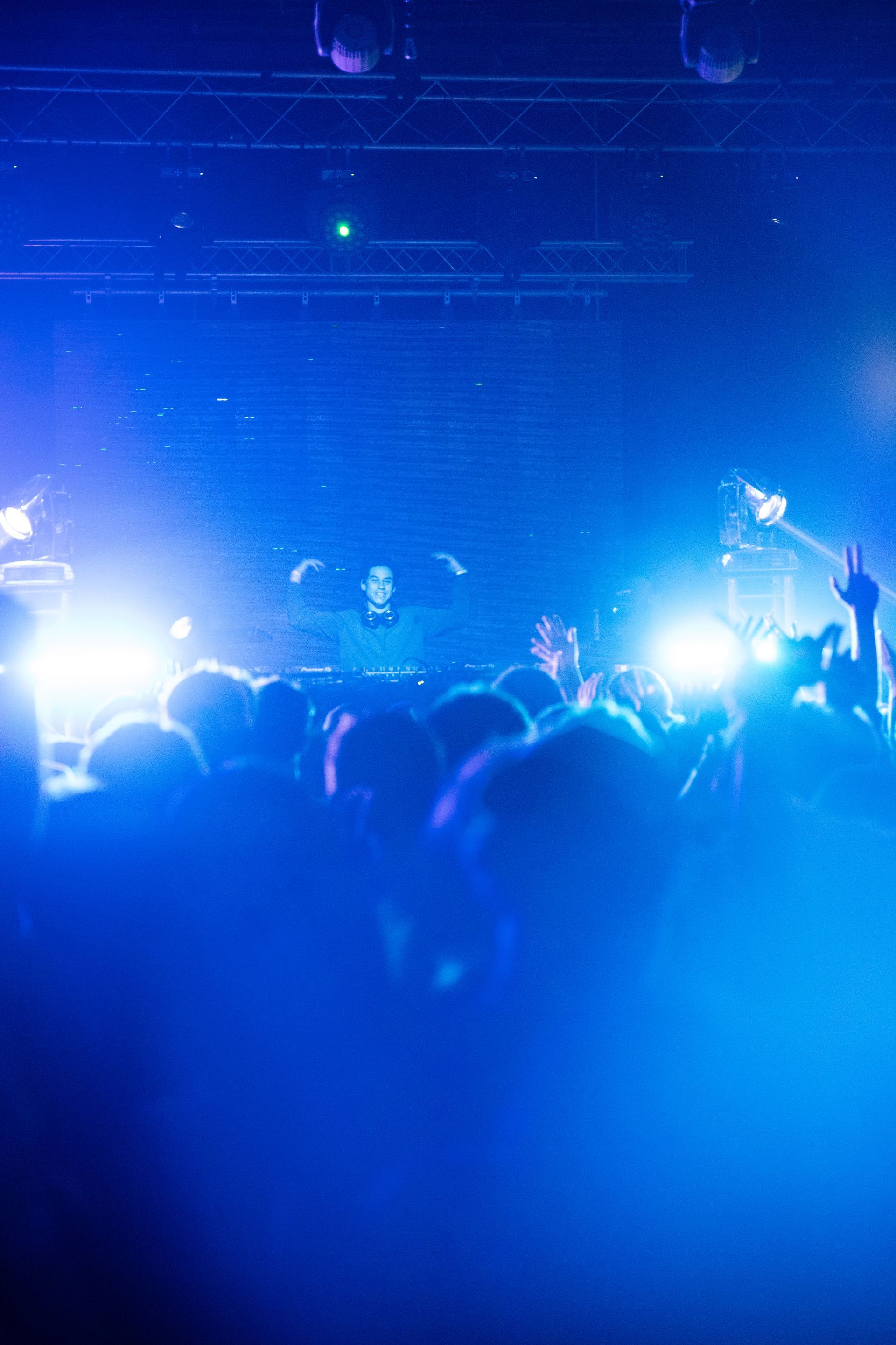 A crowd of people are standing in front of a stage at a concert.