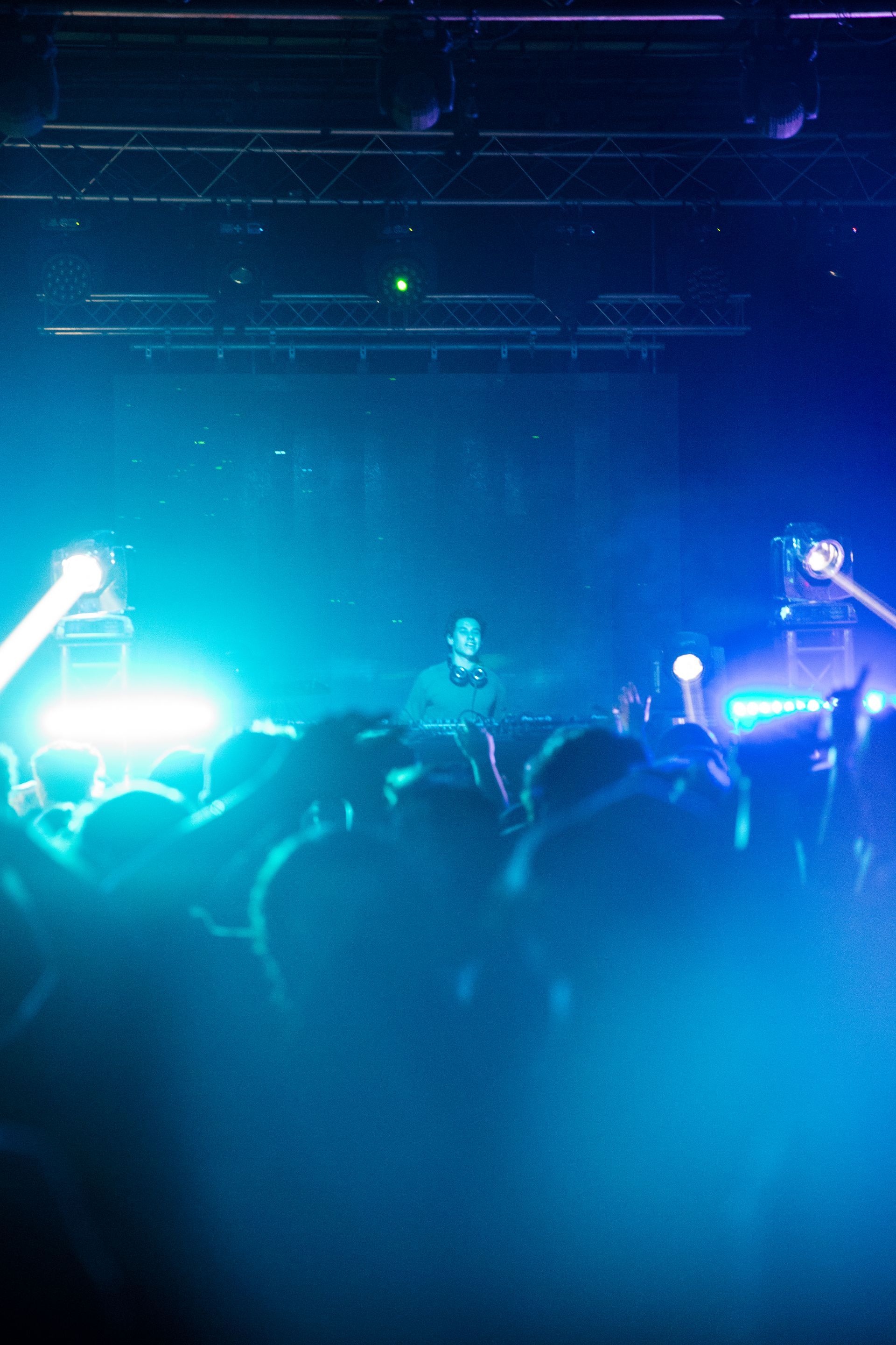 A crowd of people are standing in front of a stage at a concert.