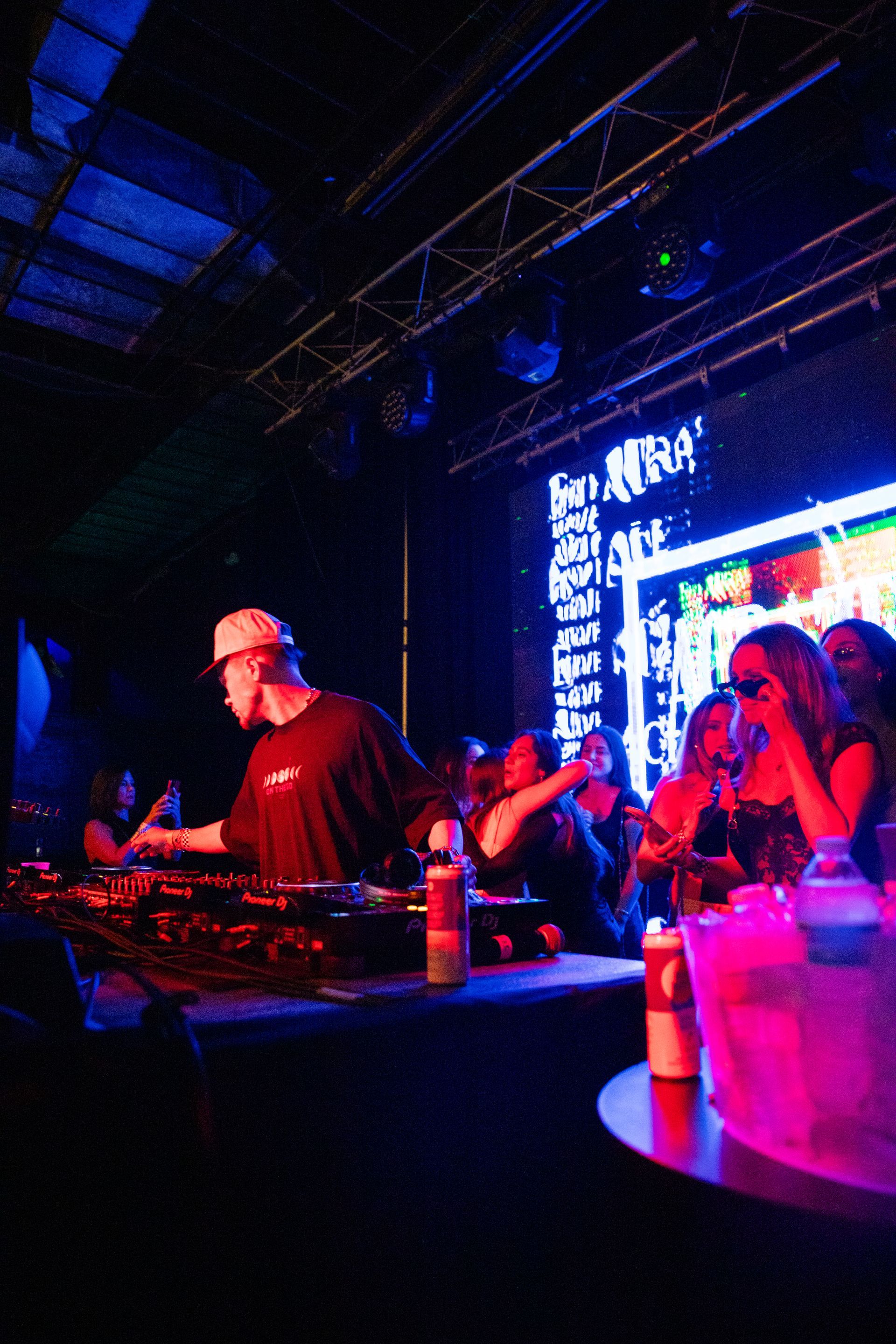 A man is playing a dj set in front of a crowd