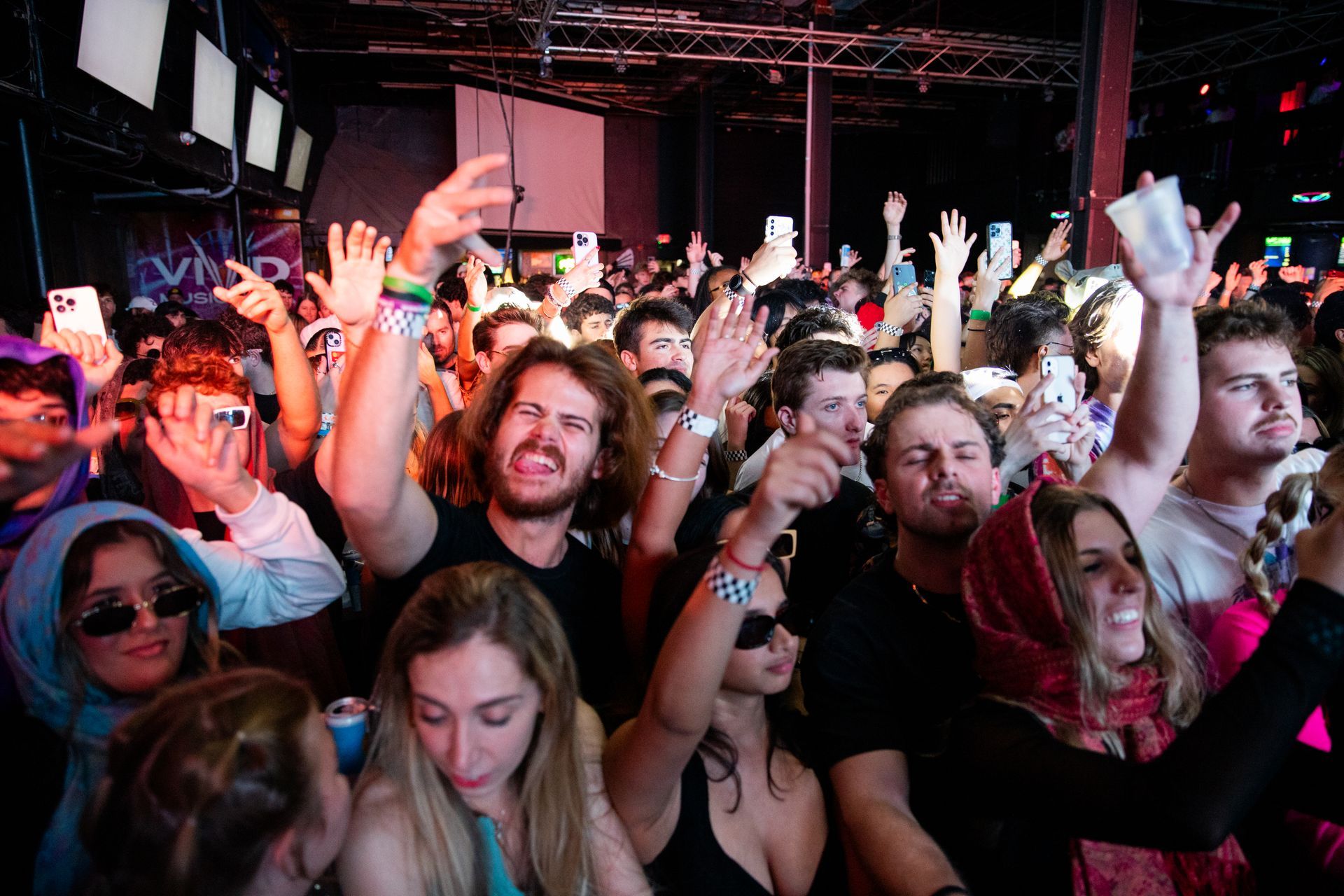 A crowd of people are dancing at a concert.