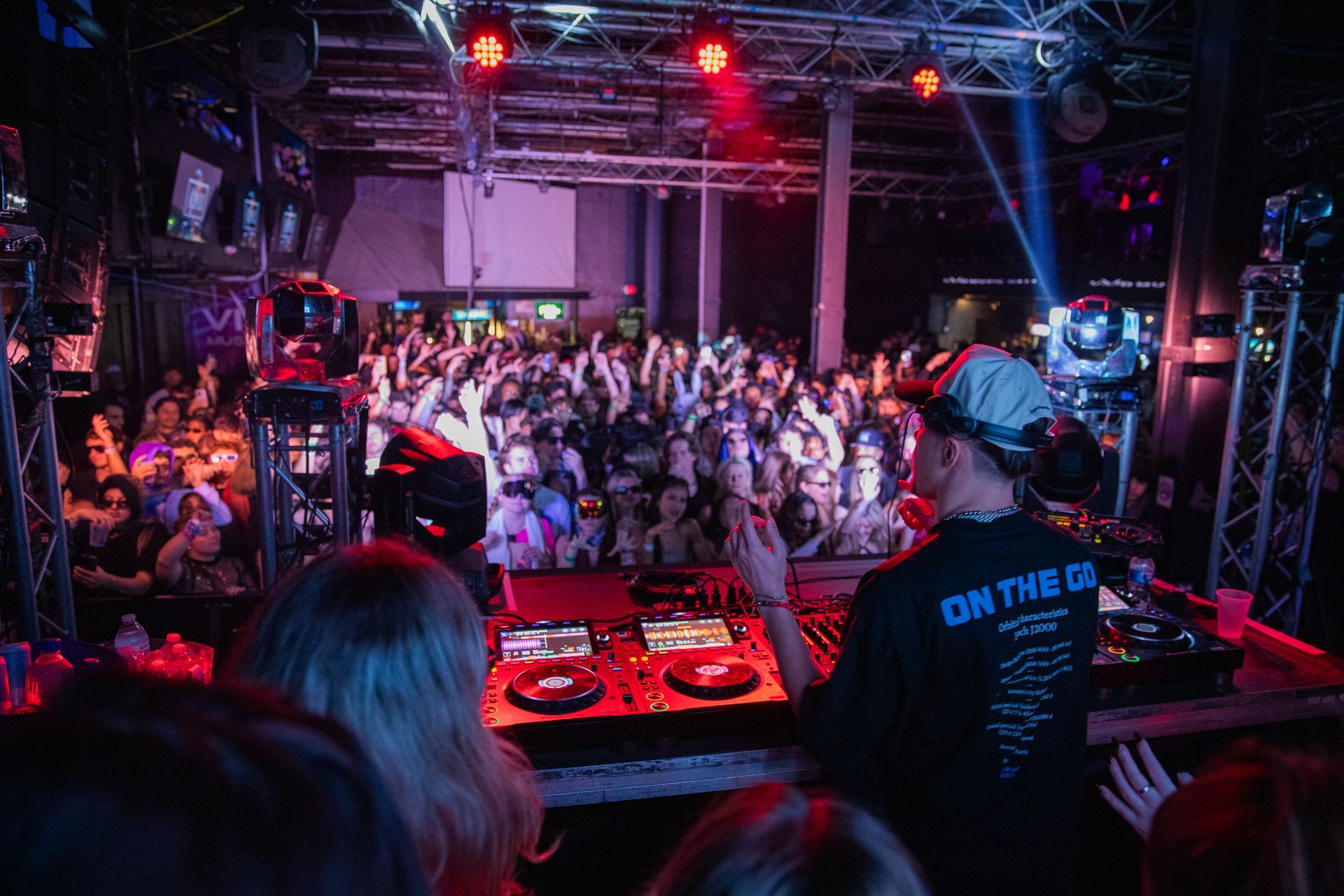 A dj is playing music in front of a crowd at a party.