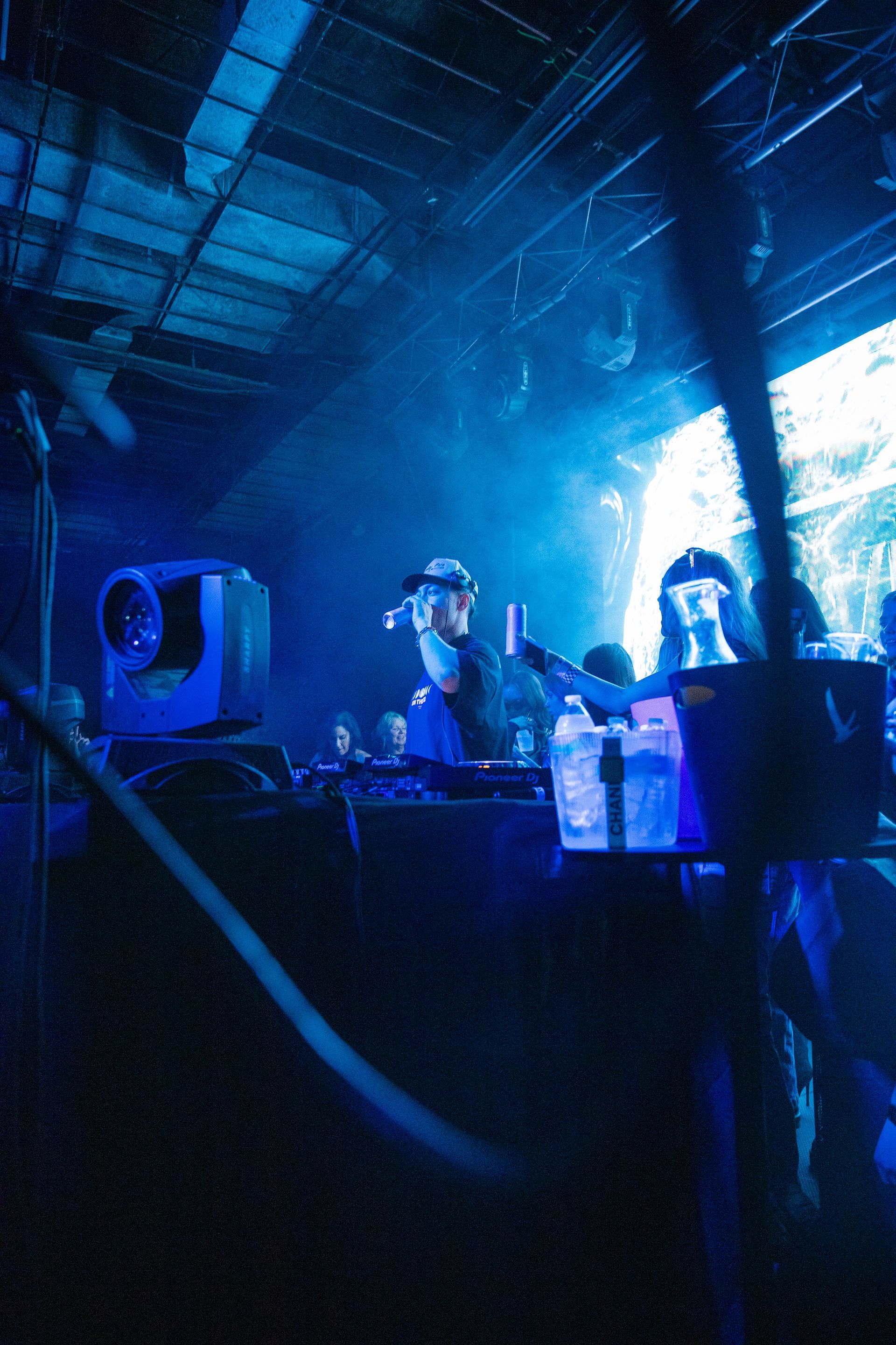 A group of people playing instruments in a dark room with blue lights
