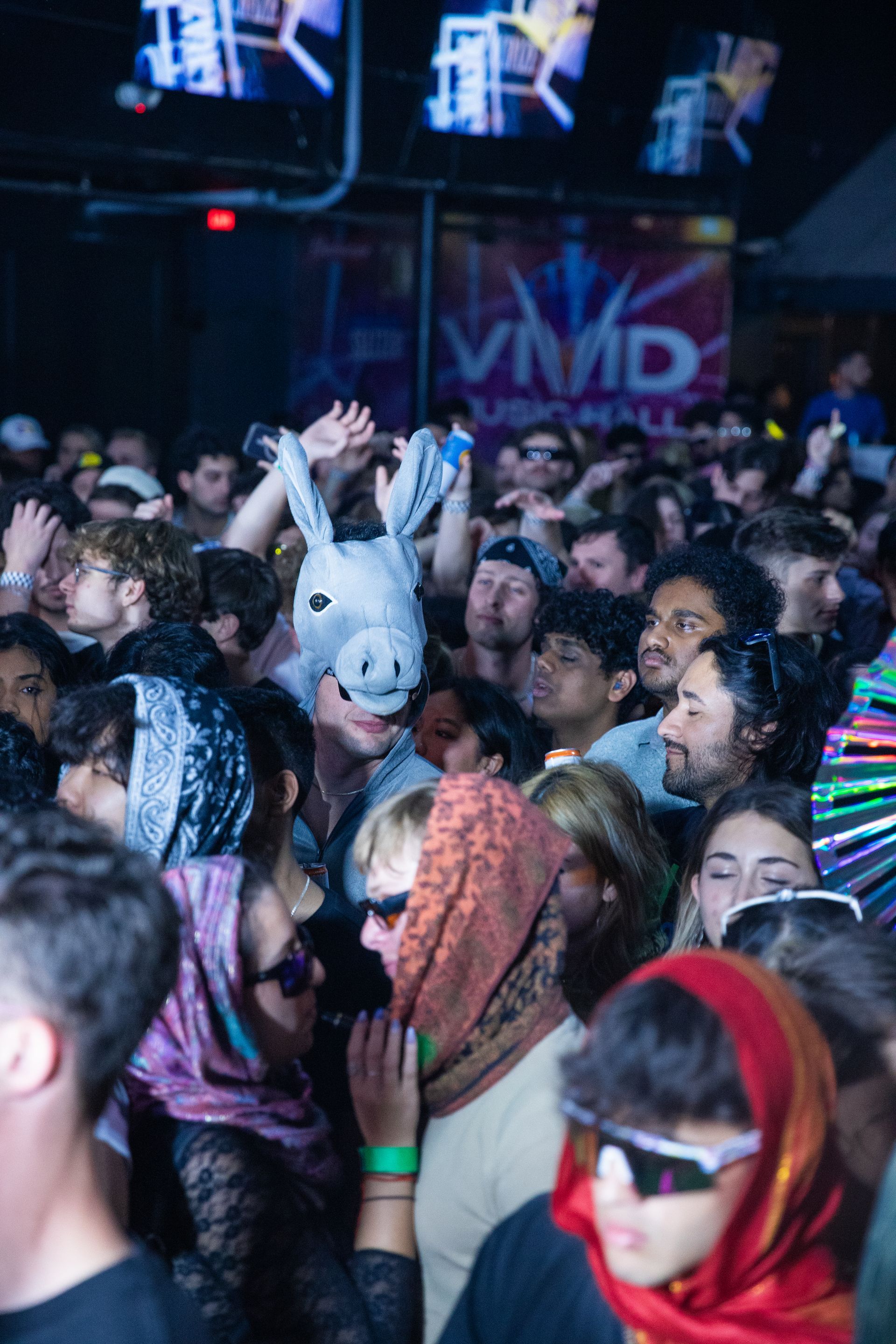 A crowd of people are standing in front of a sign that says vivid