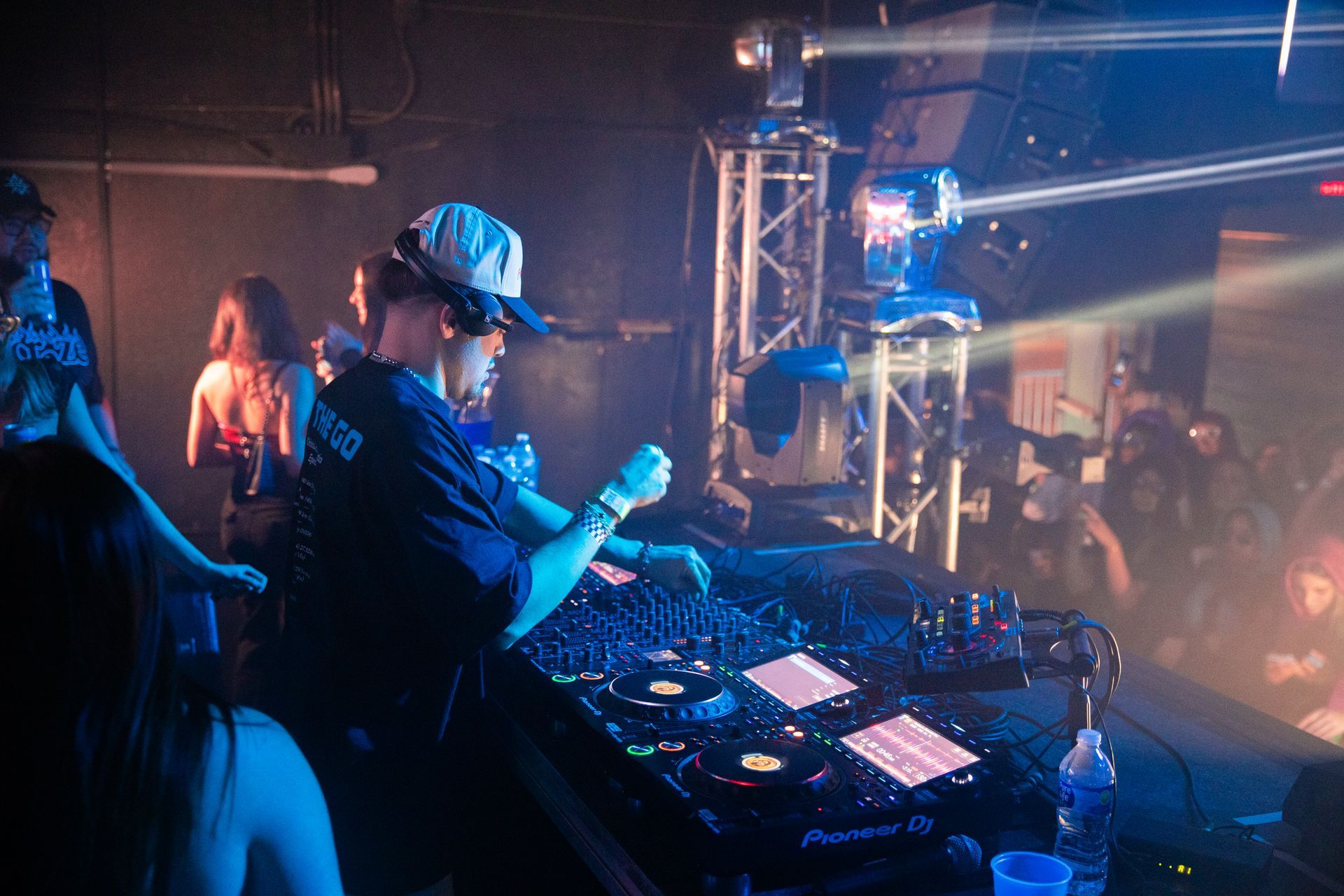 A man is playing a dj set in a dark room.