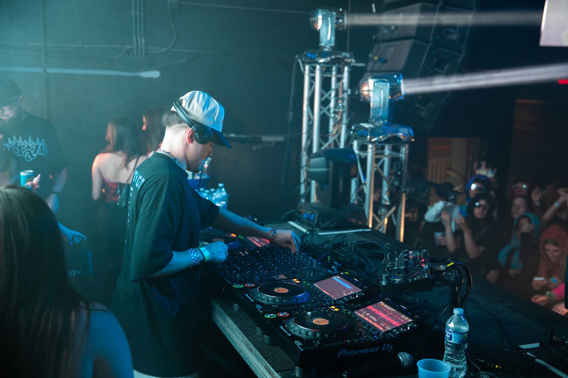 A dj is playing music at a party in front of a crowd.