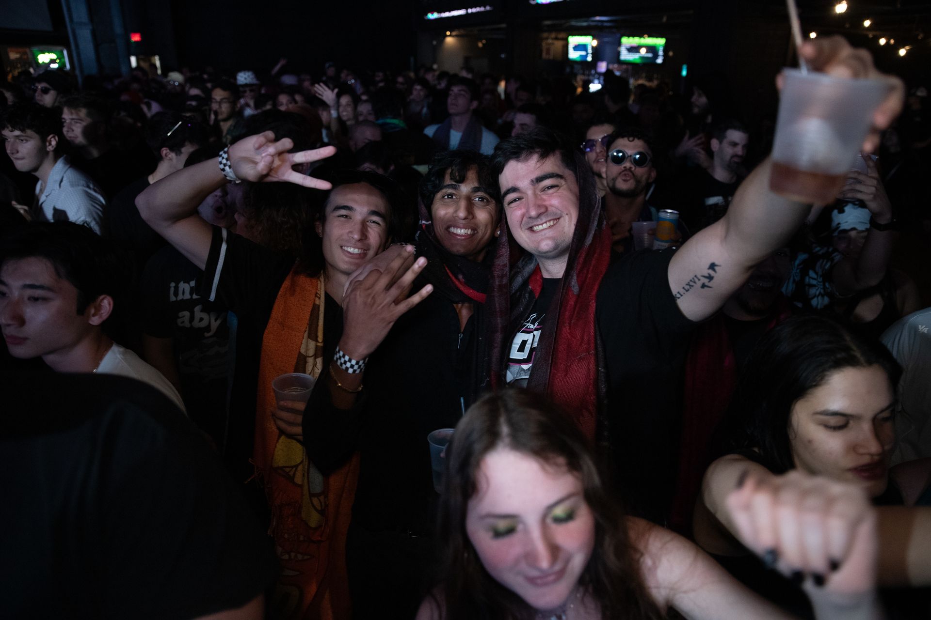 A crowd of people are dancing in a dark room.