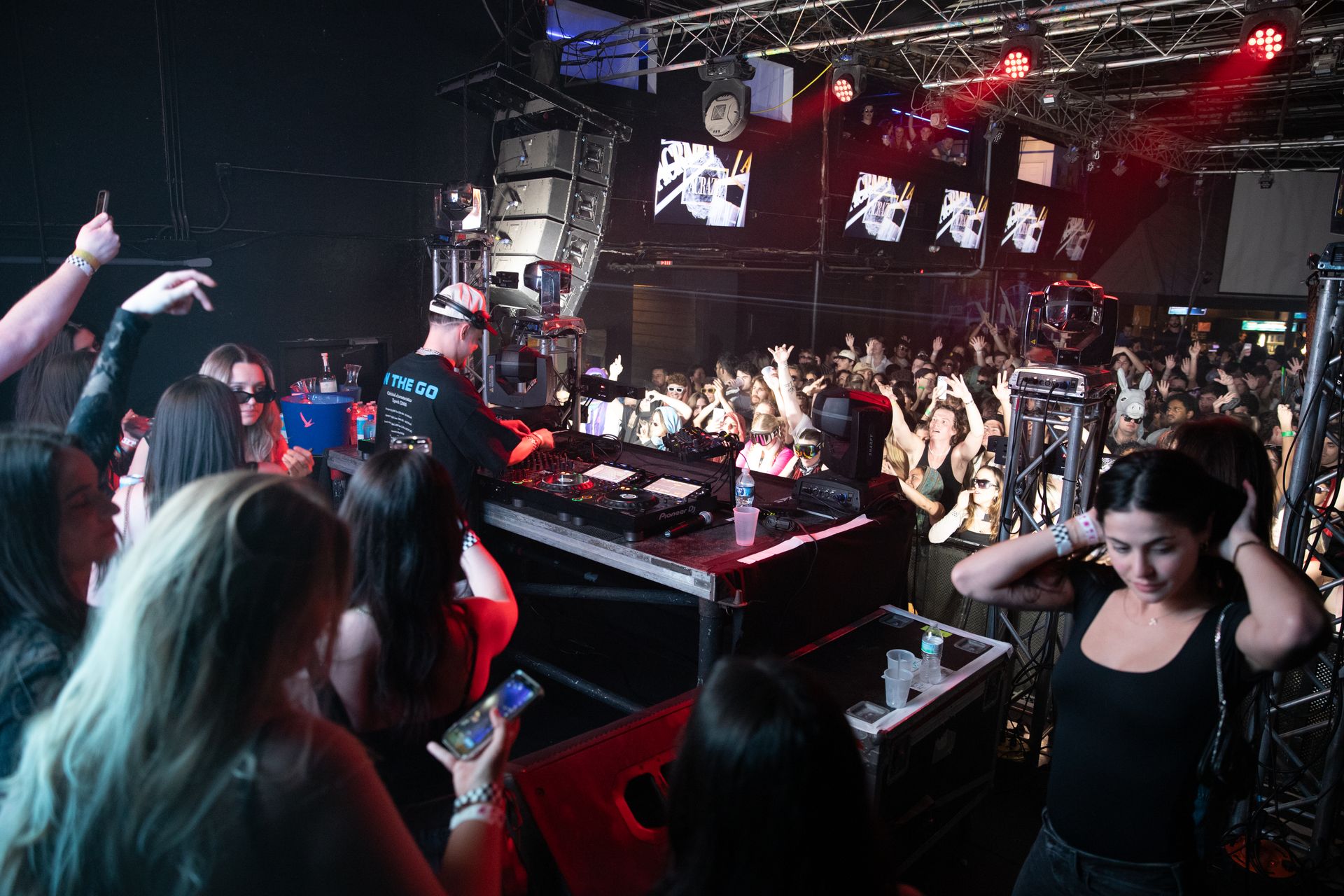 A group of people are standing in front of a stage at a concert.