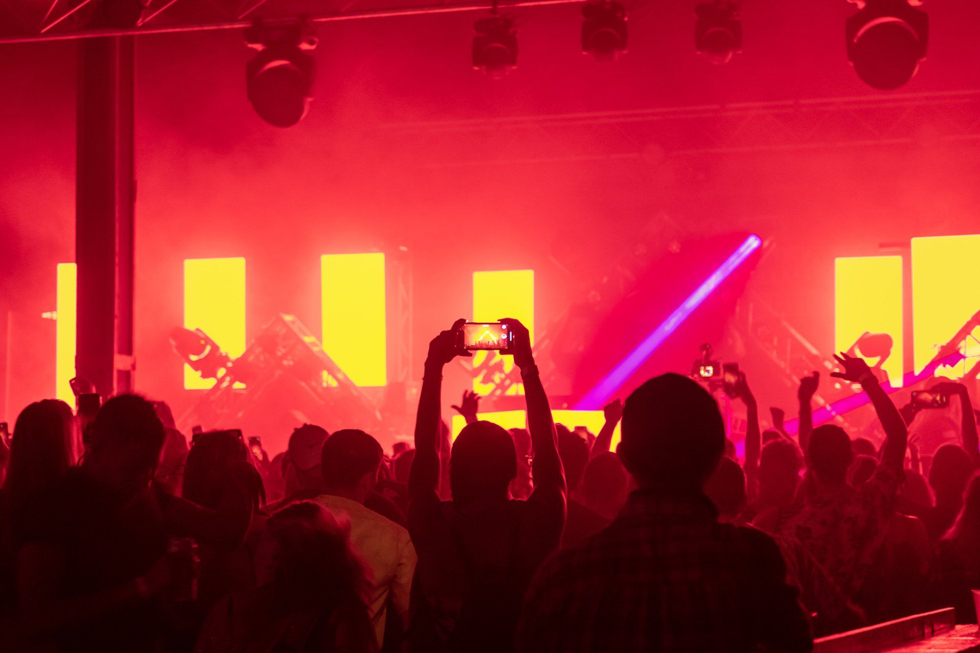A crowd of people are standing in front of a stage at a concert.
